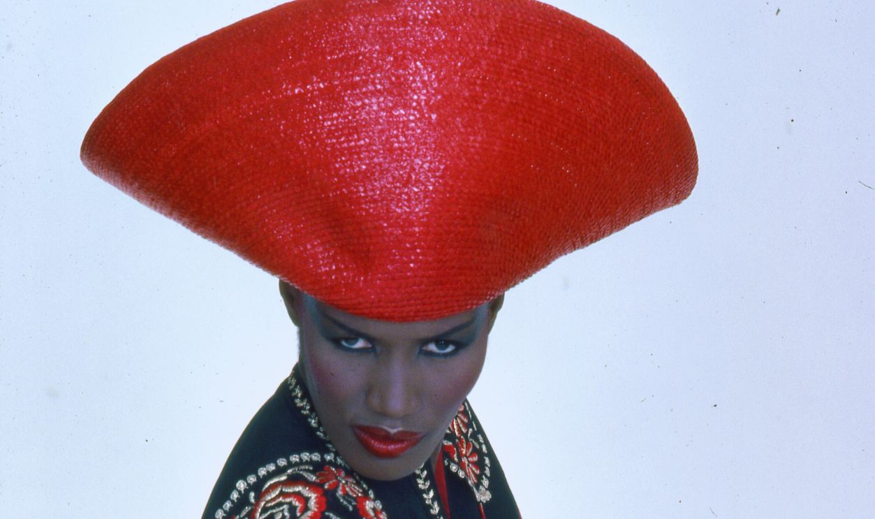 Gettyimages - 149314351, Portrait Of Grace Jones Portrait of Jamaican-born model, singer, and actress Grace Jones as she wears a bright red hat and multi-colored top, New York, New York, late twentieth century. 