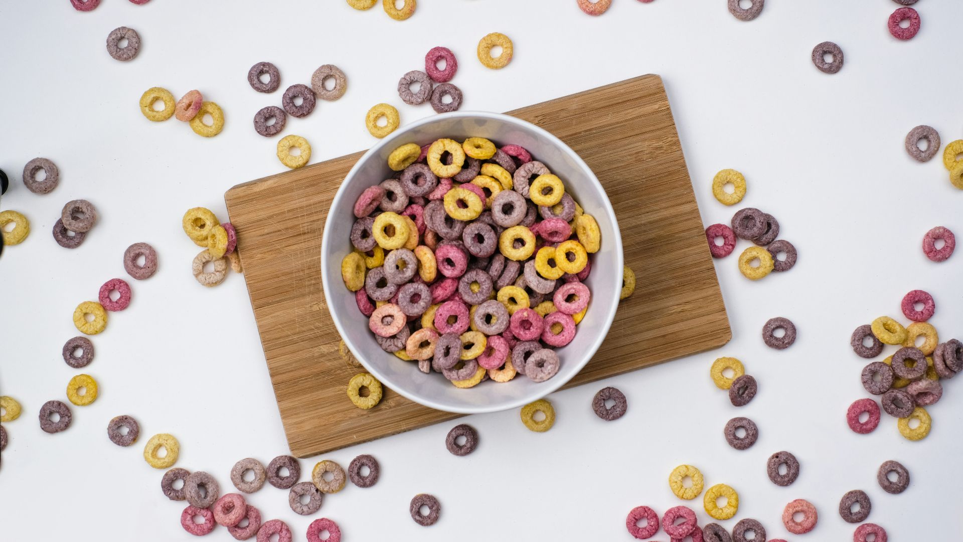 red and blue berries on white ceramic bowl on brown wooden chopping board
