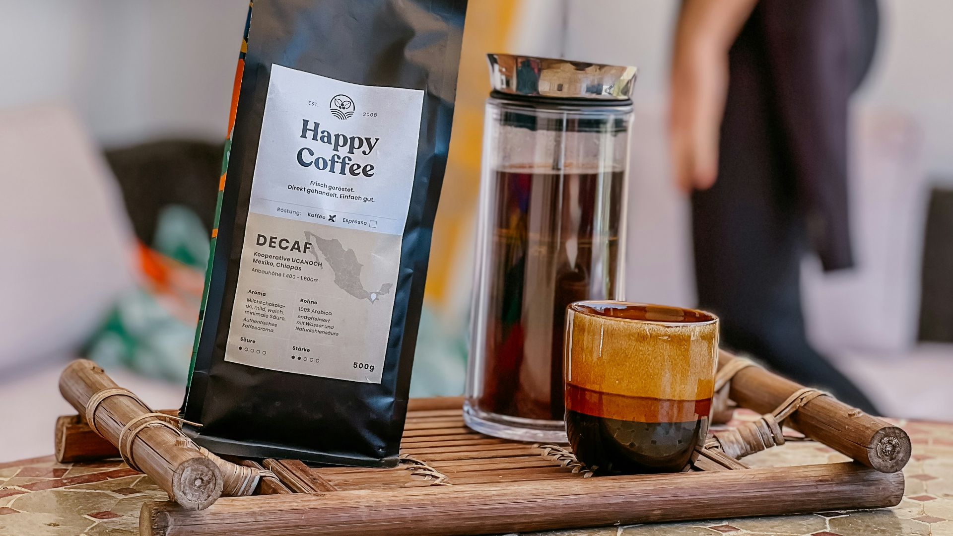 A man standing in a kitchen next to a surfboard