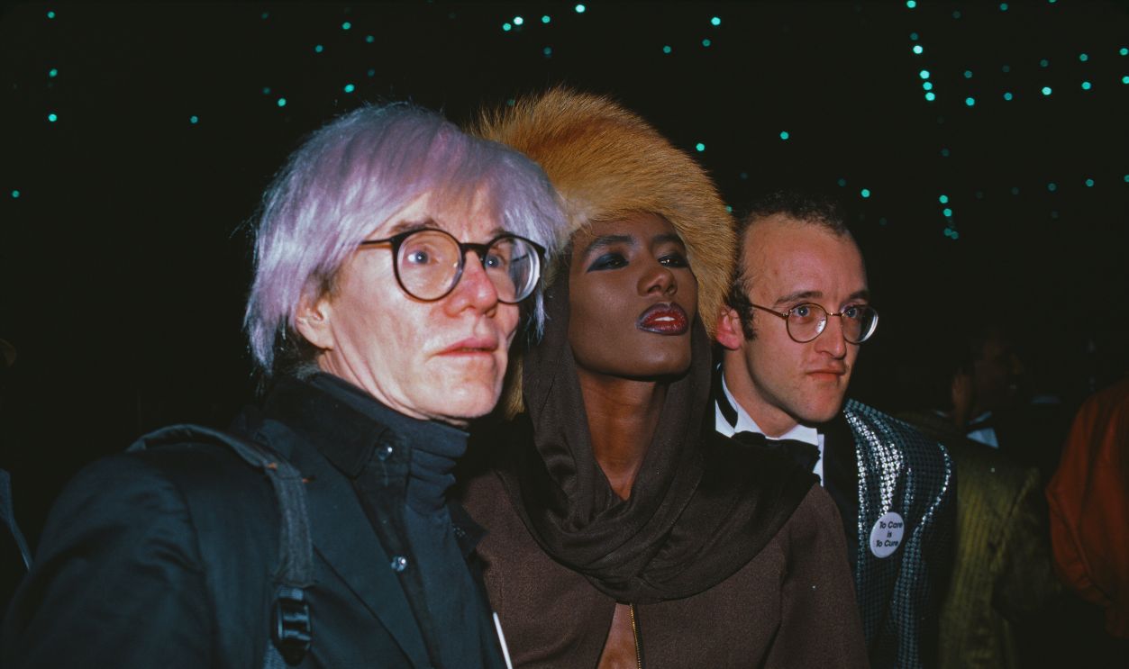   Gettyimages - 1226188979, American Foundation For AIDS Research Fundraiser American artist Andy Warhol (1928-1987), Jamaican model and singer Grace Jones, and American artist Keith Haring (1958-1990) attend an American Foundation for AIDS Research fundraiser, held at the Jacob Javits Center in New York City, New York, 1st May 1986. 