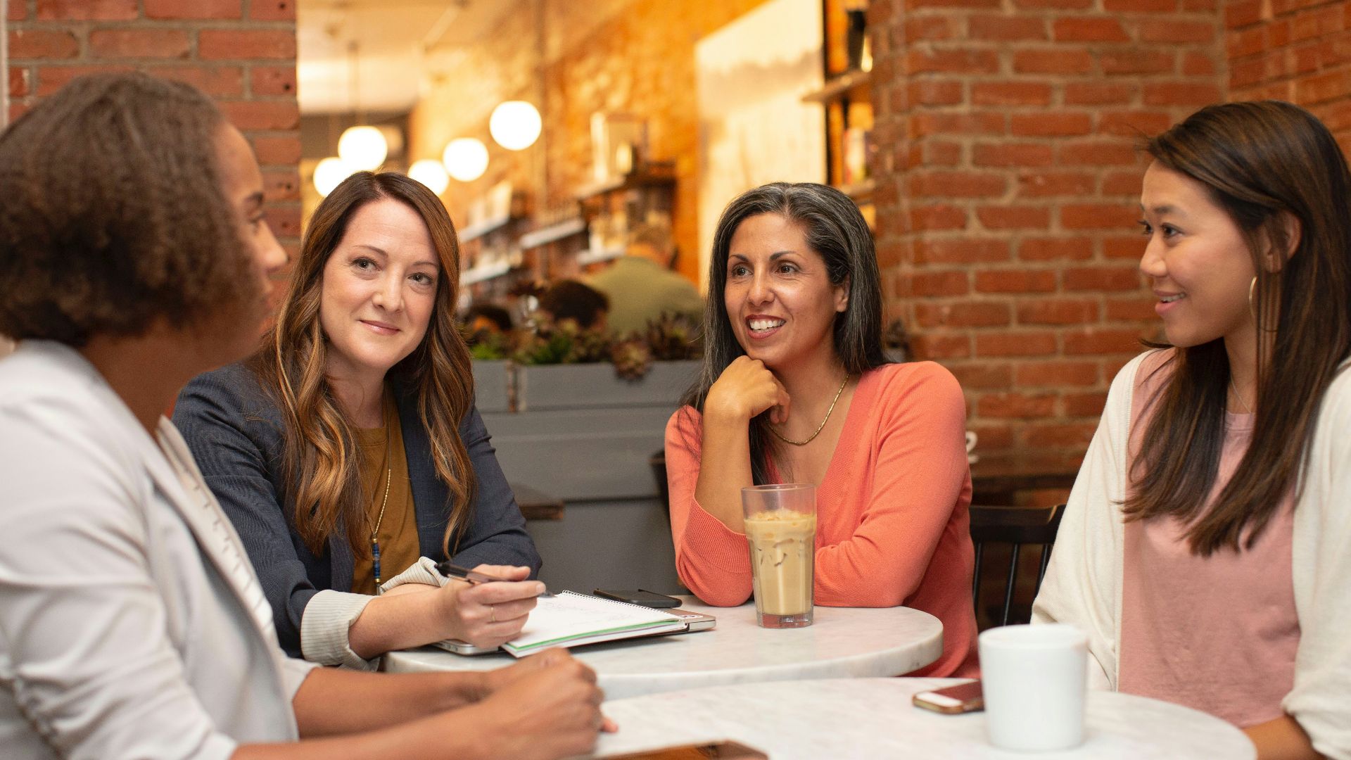 woman in black jacket sitting beside woman in white blazer