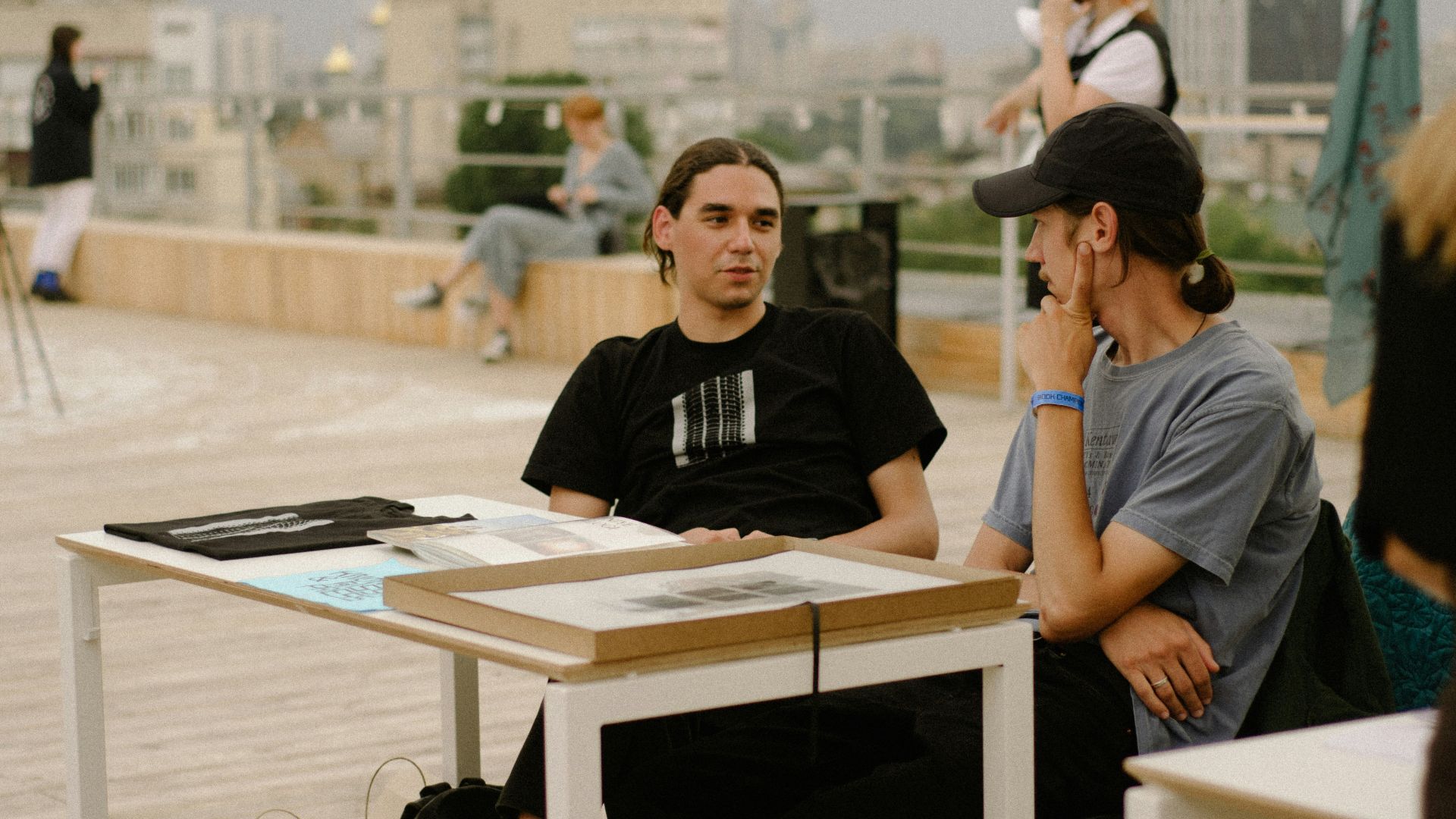 a man sitting at a table talking on a cell phone