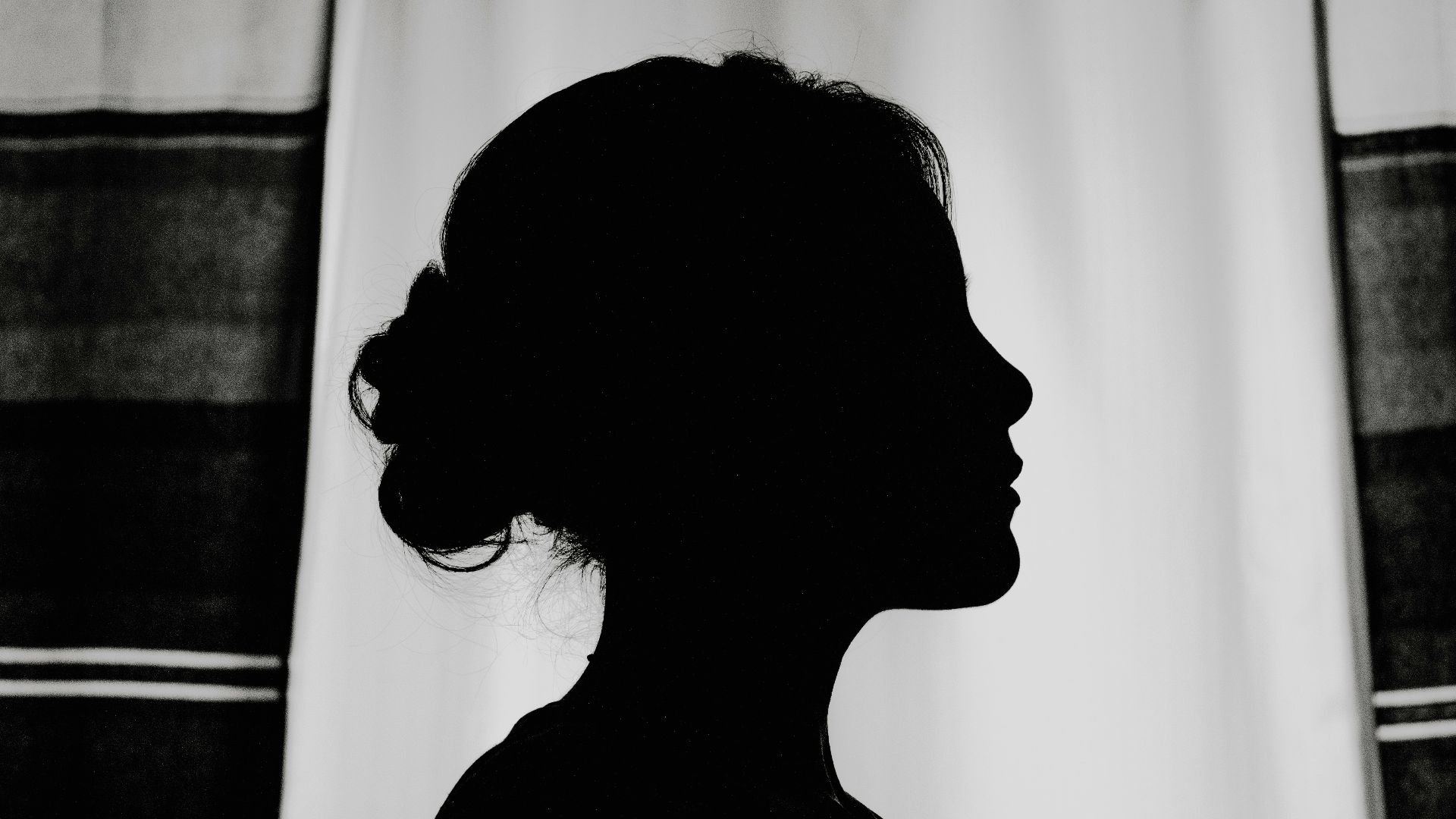 silhouette of woman standing near window