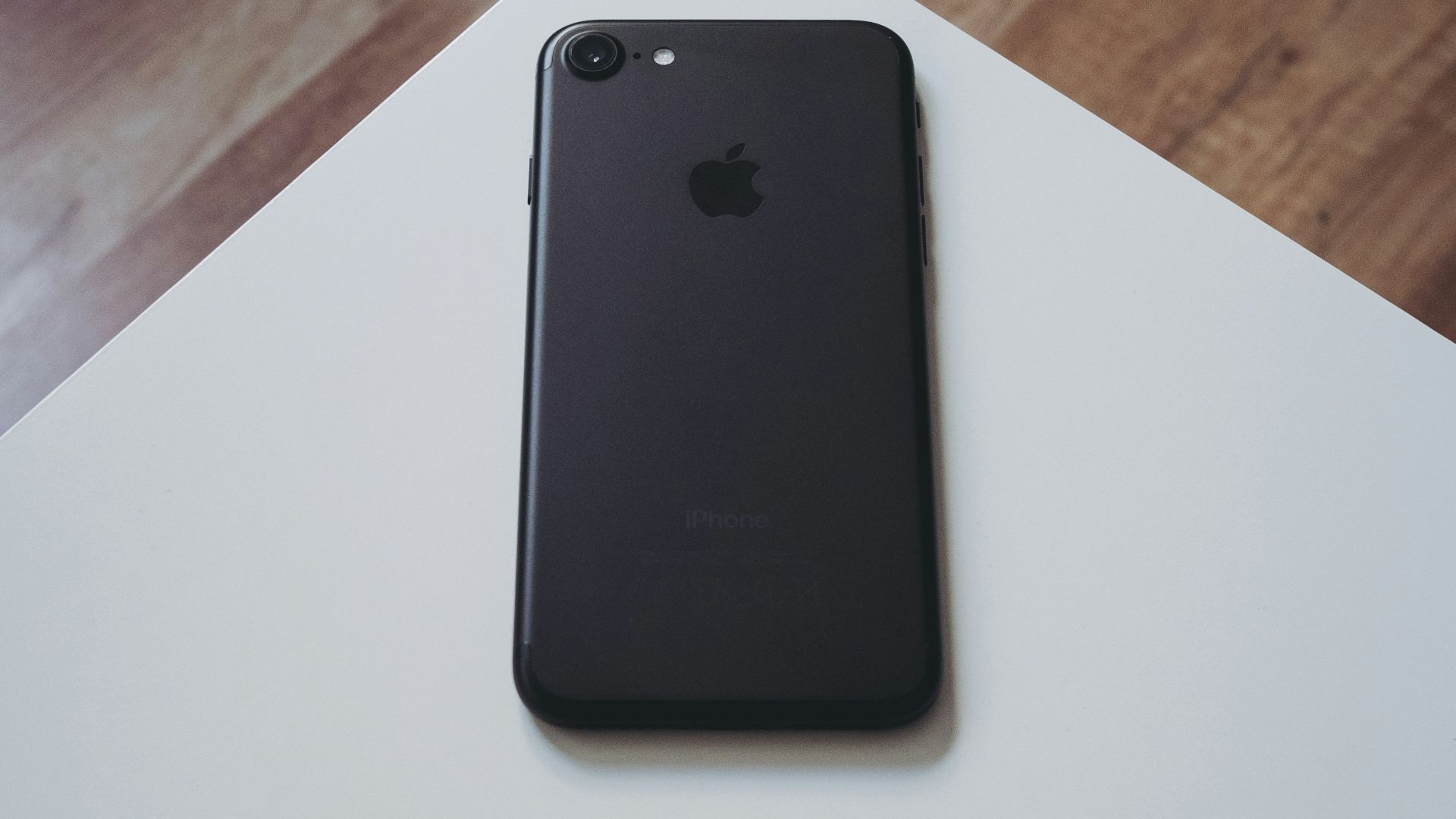 black iPhone 7 on white wooden table