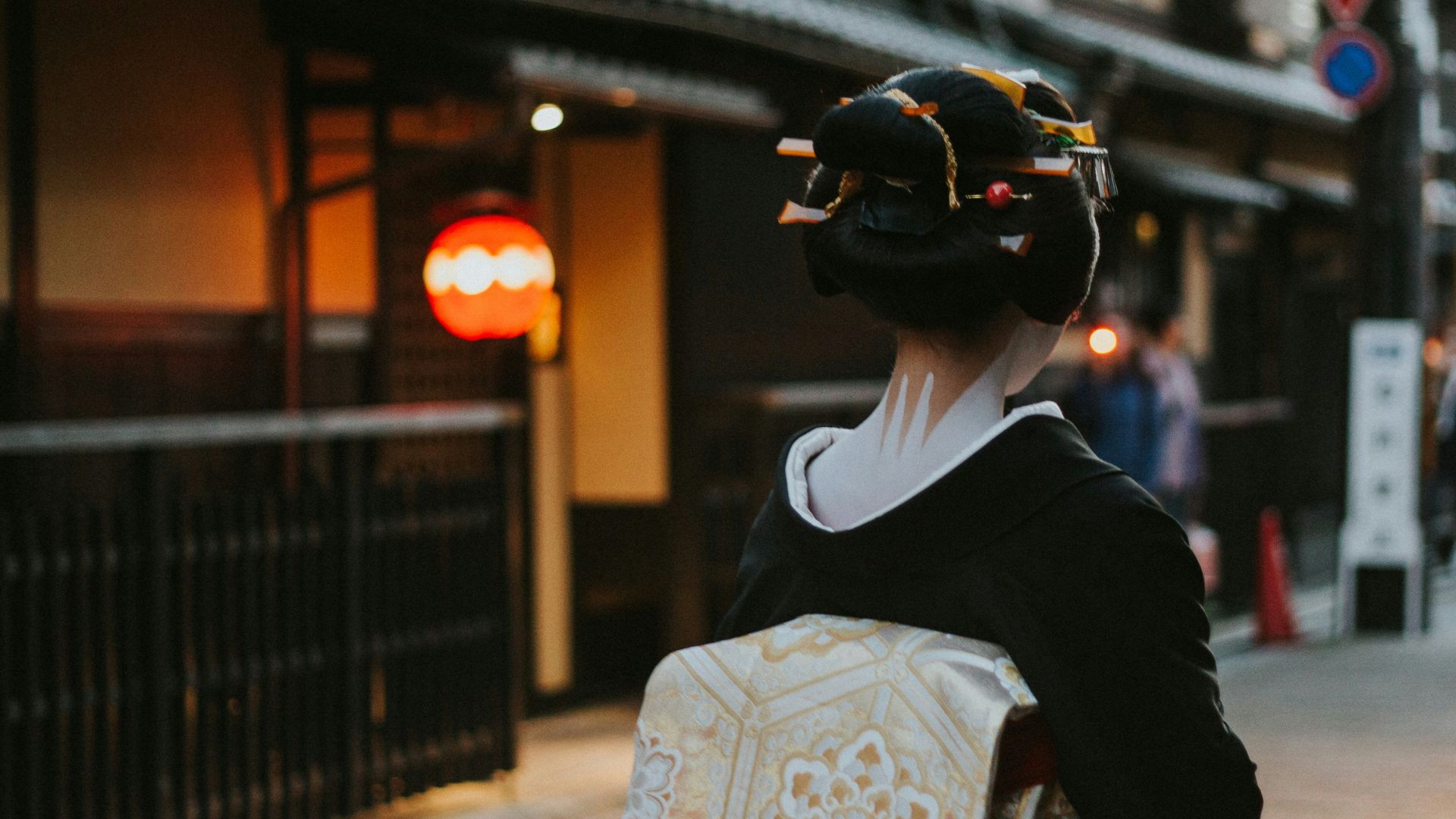 woman in black and white floral kimono walking on sidewalk during daytime