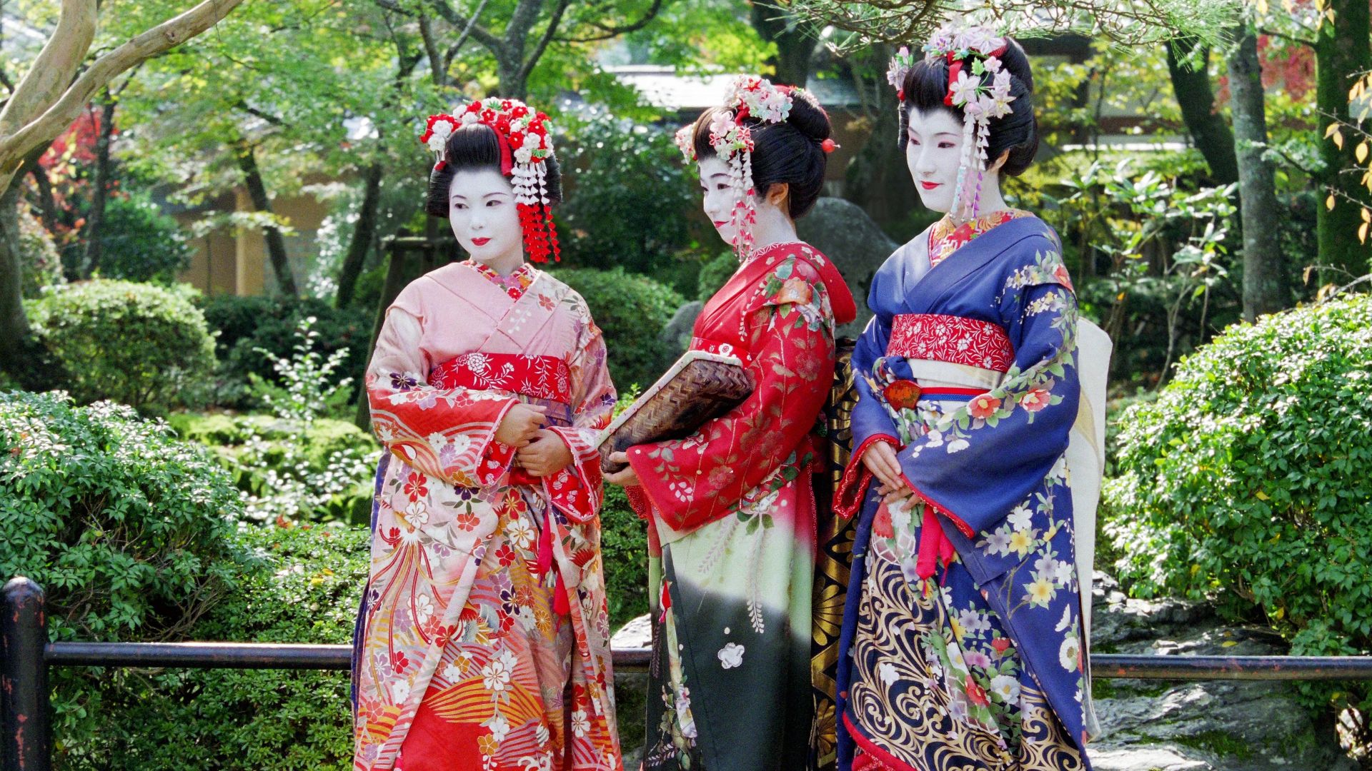 2 women in red and blue floral kimono standing on white sand during daytime