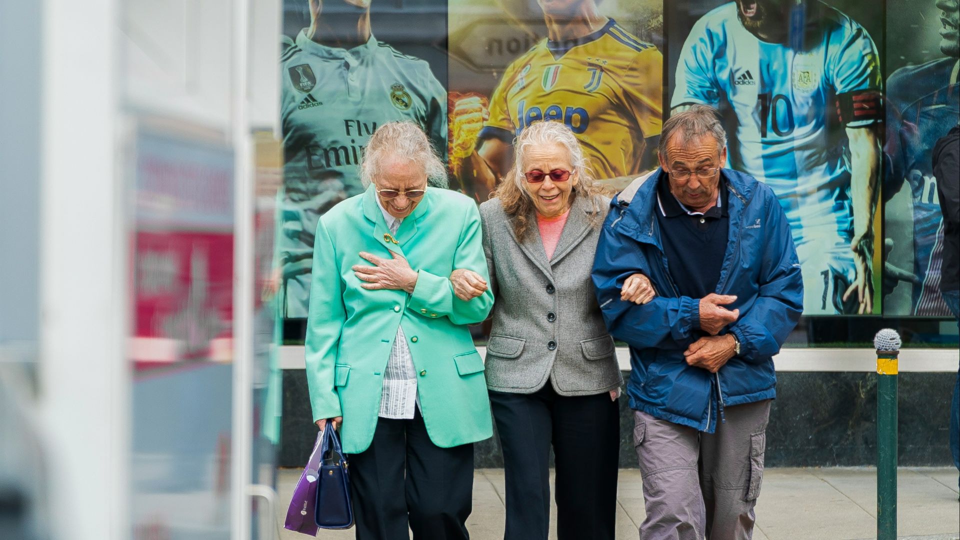 two women and man walking in the street during daytime