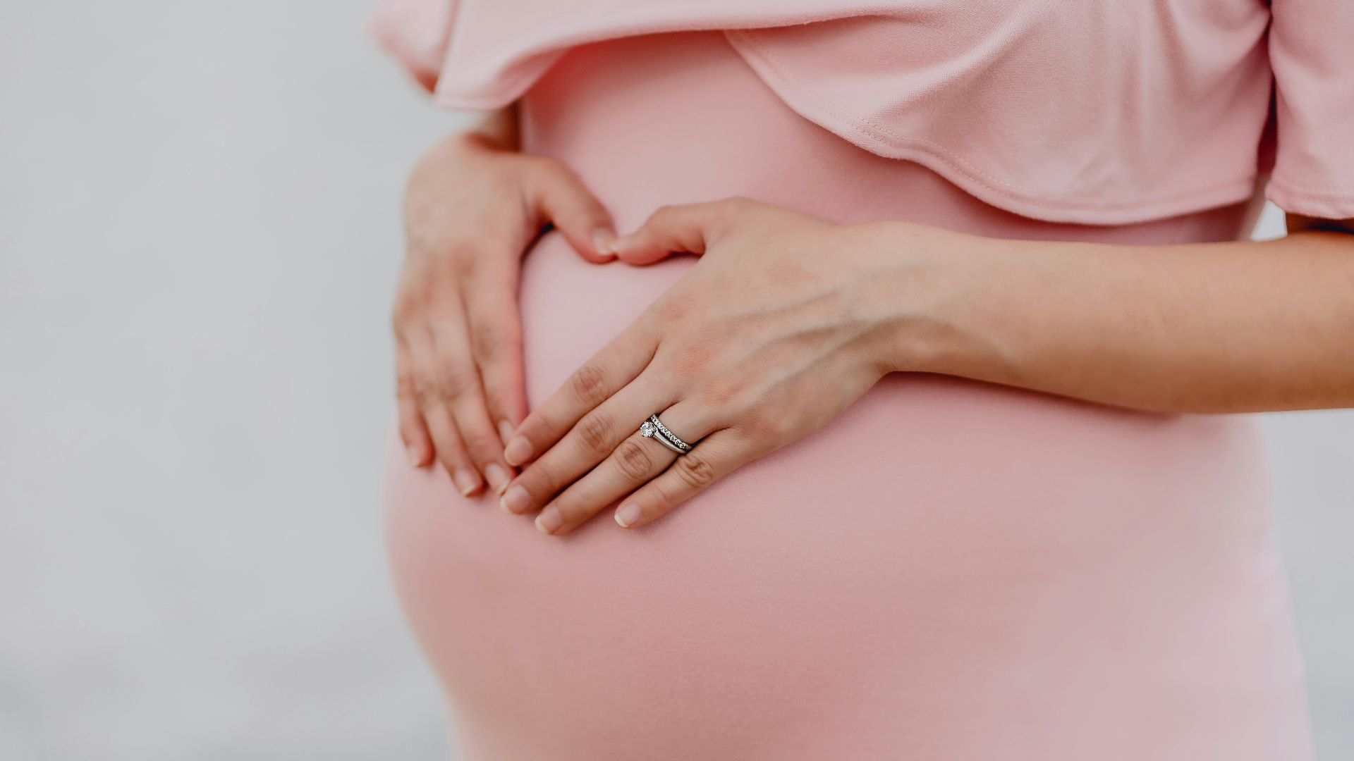 woman wearing gold ring and pink dress