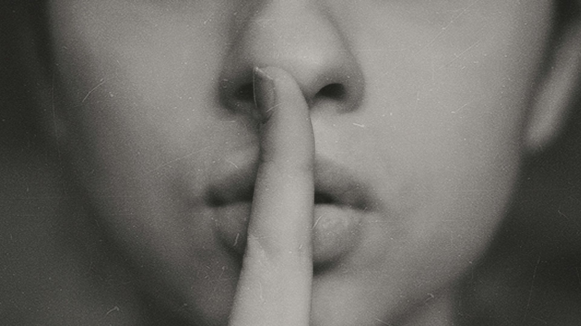 grayscale photo of woman doing silent hand sign