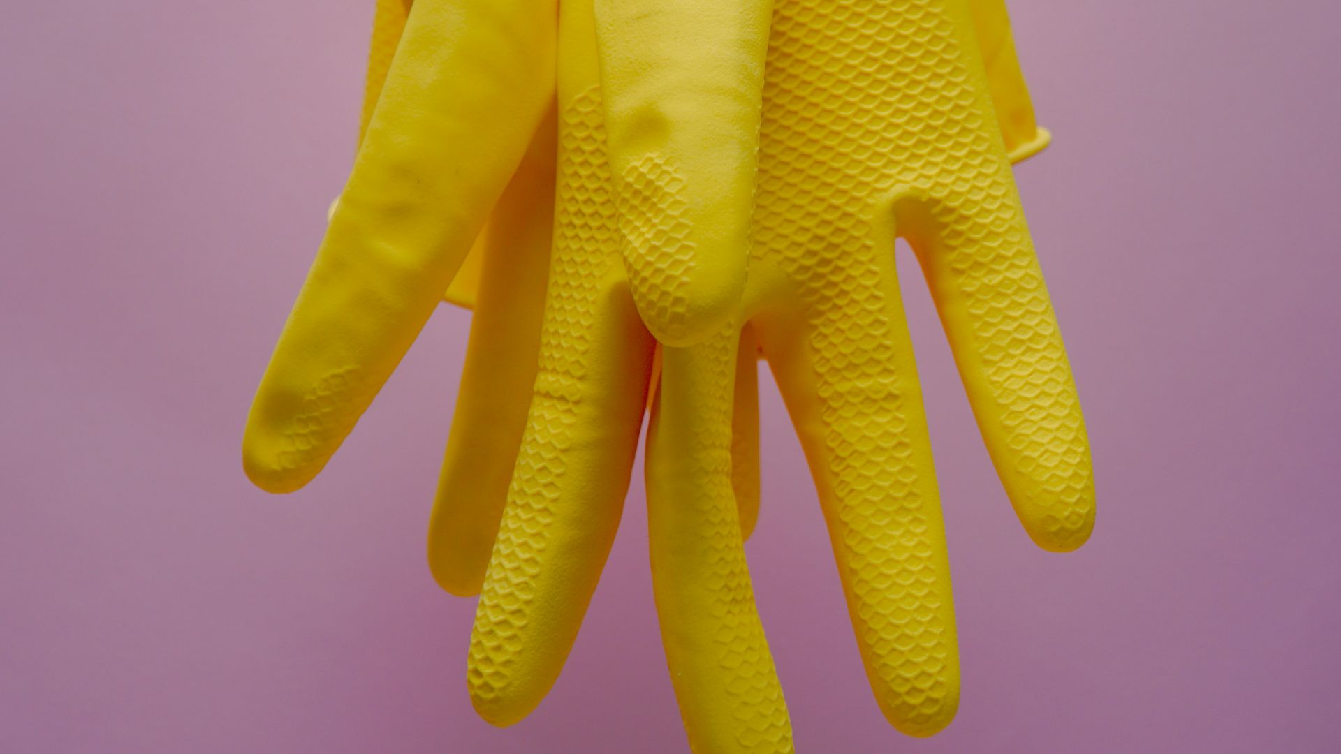yellow gloves on blue clothes hanger