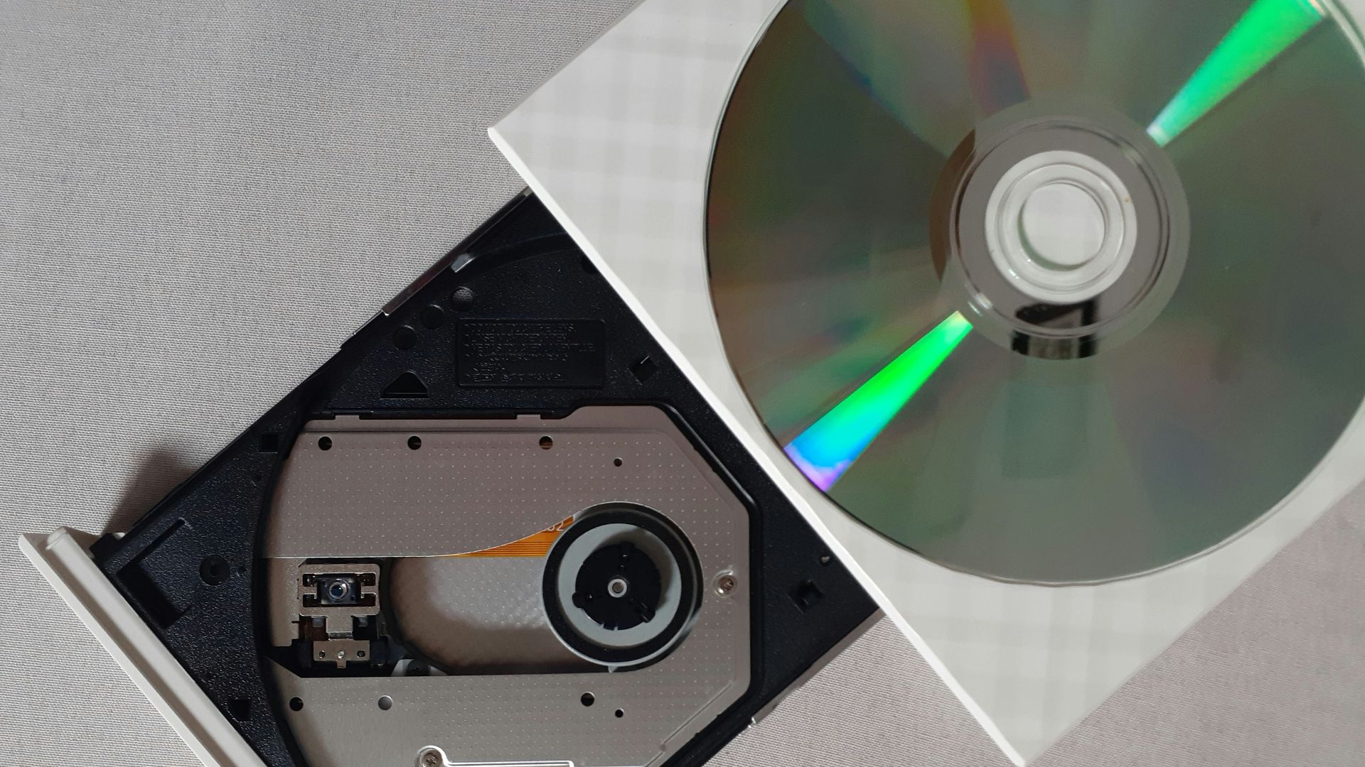 silver compact disc on black cd rack