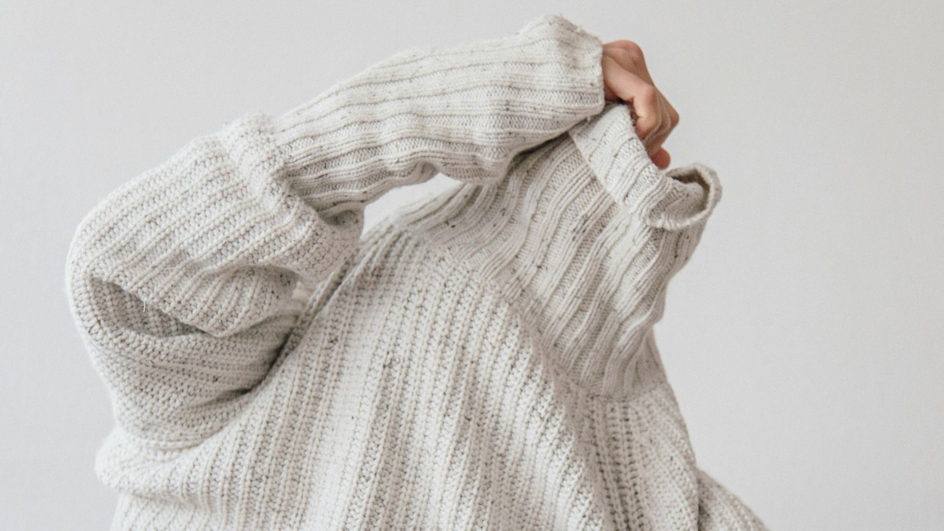 person wearing grey knit sweater