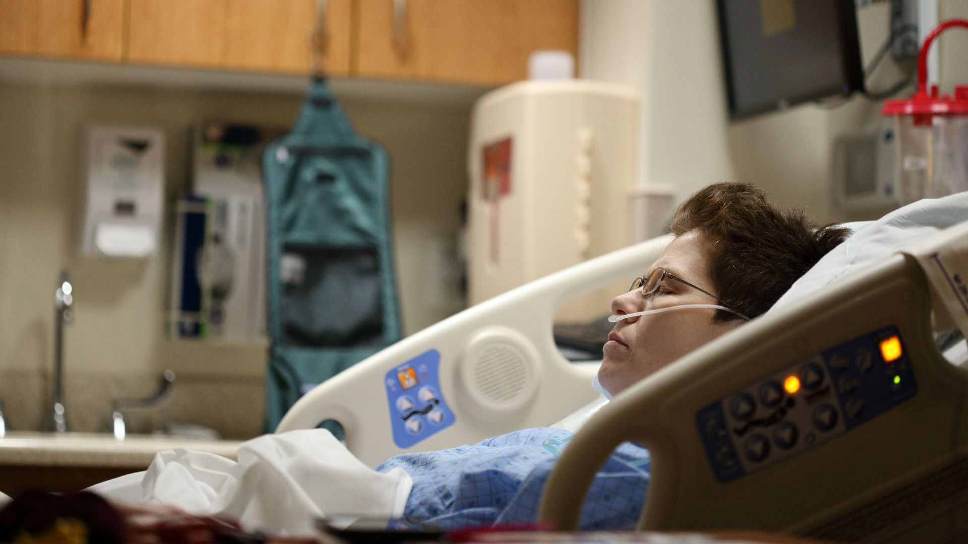 boy lying on beige recliner hospital bed