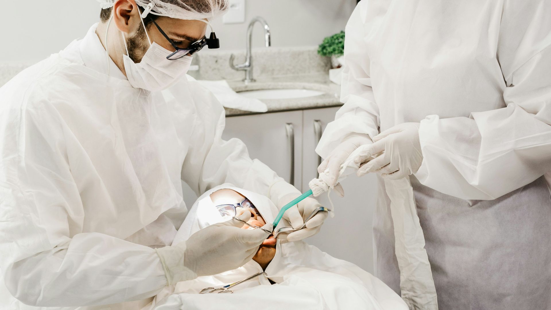 woman in white scrub suit holding white and green hose