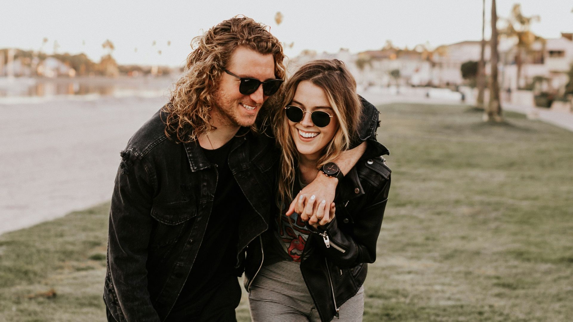 woman in black leather jacket and gray pants standing on green grass field during daytime