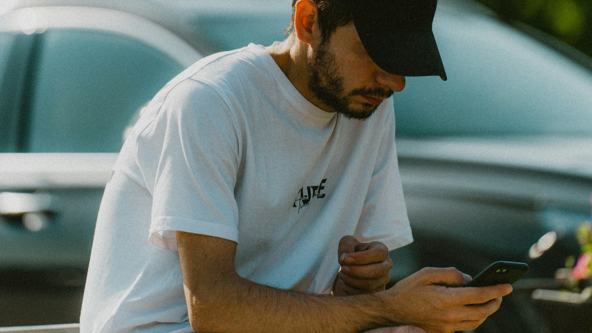 a man sitting on a bench looking at his cell phone