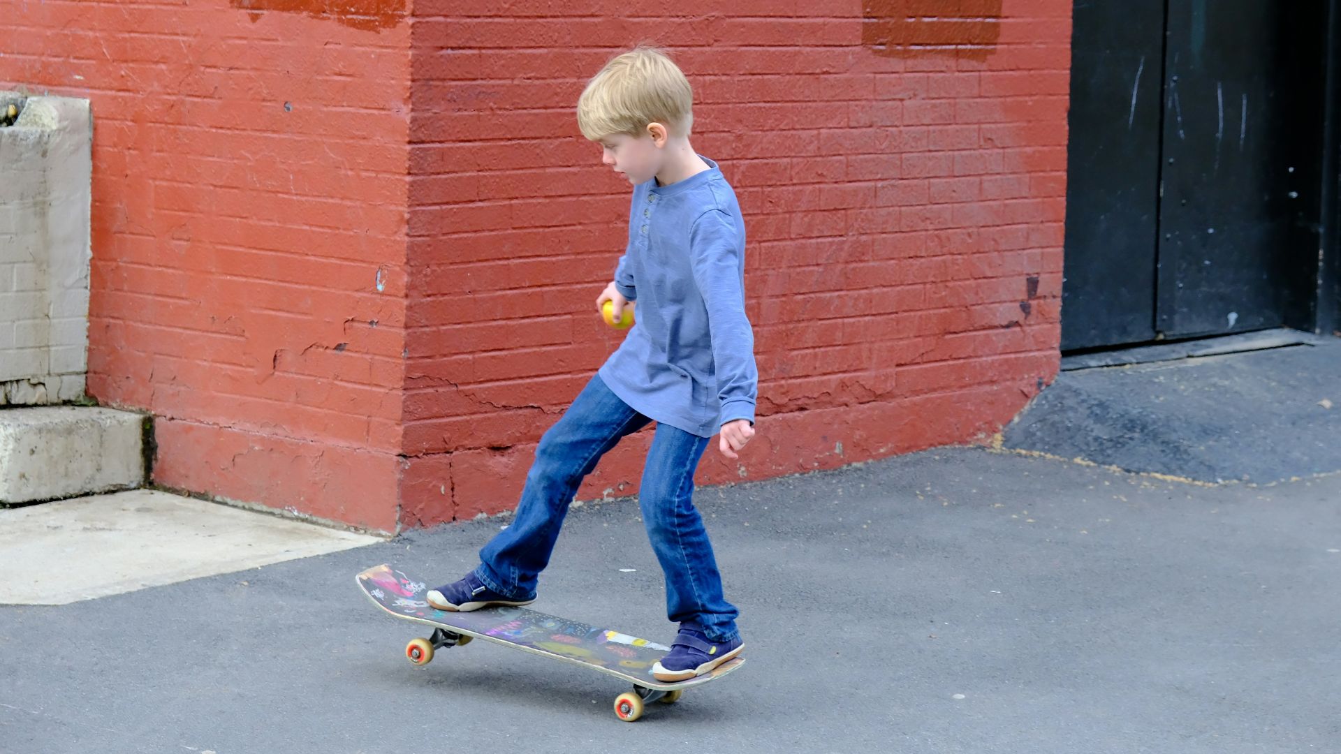 a young boy riding a skateboard down a street