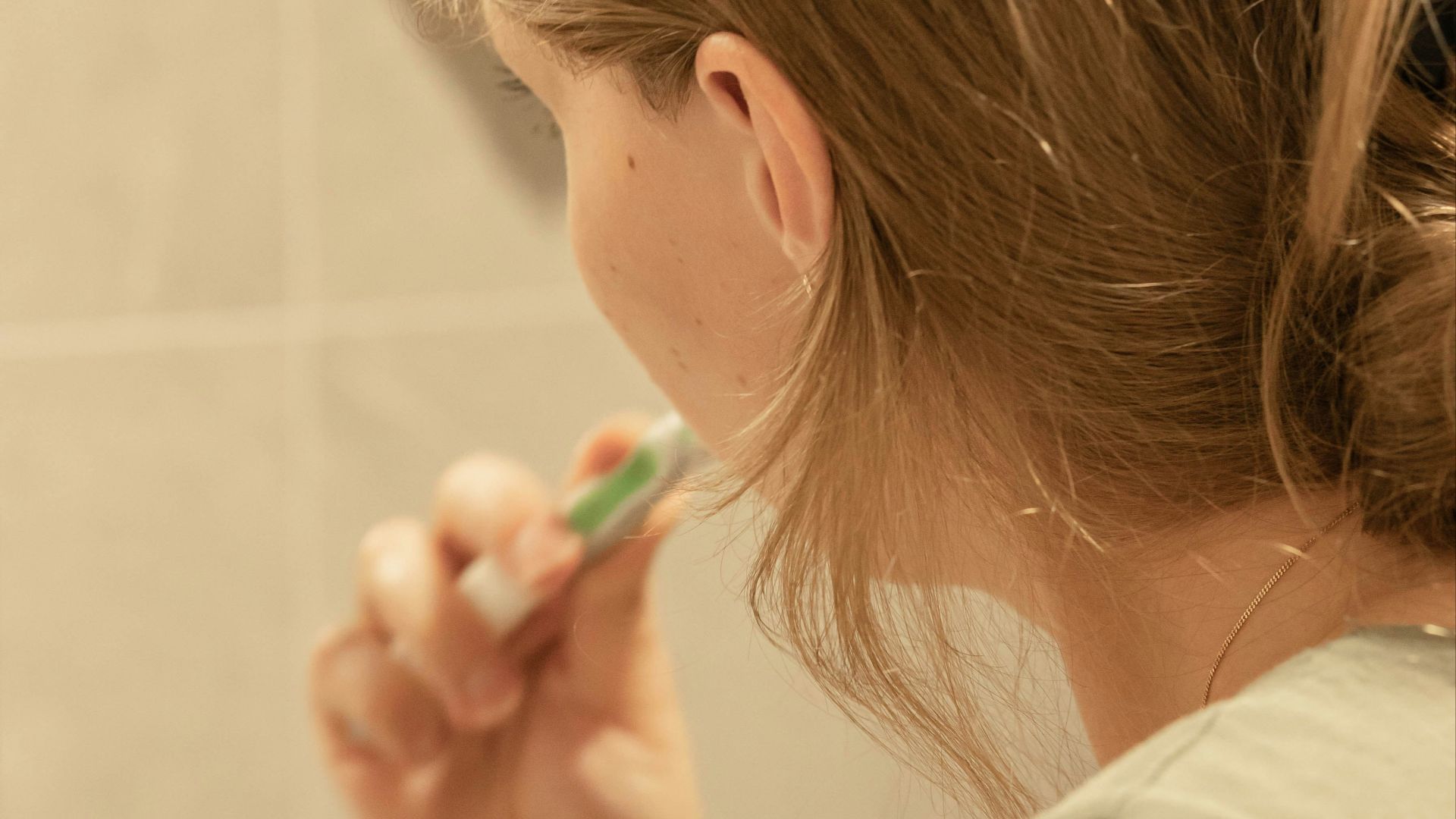 a woman brushing her teeth in front of a mirror