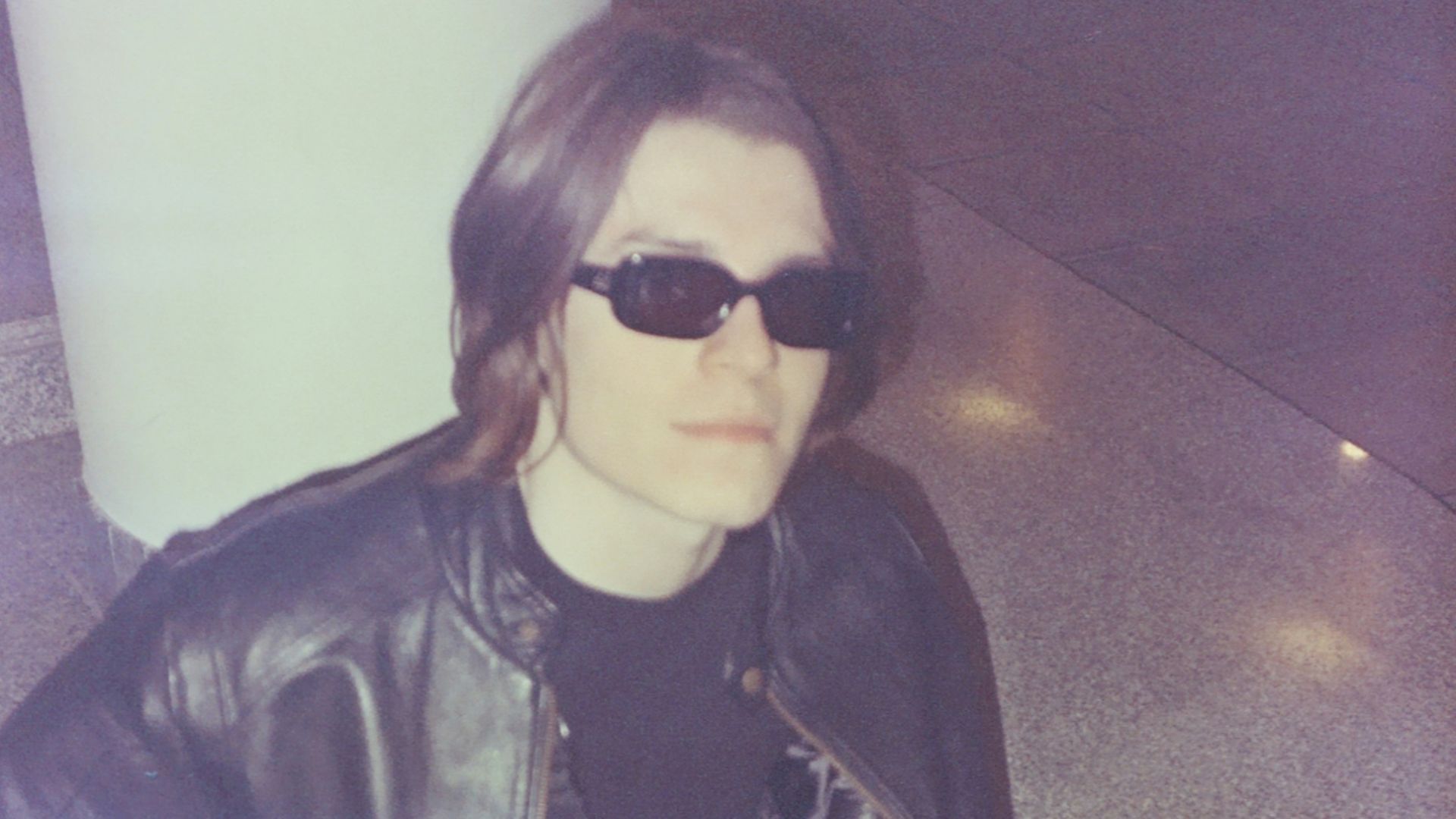 a man sitting on the ground wearing sunglasses