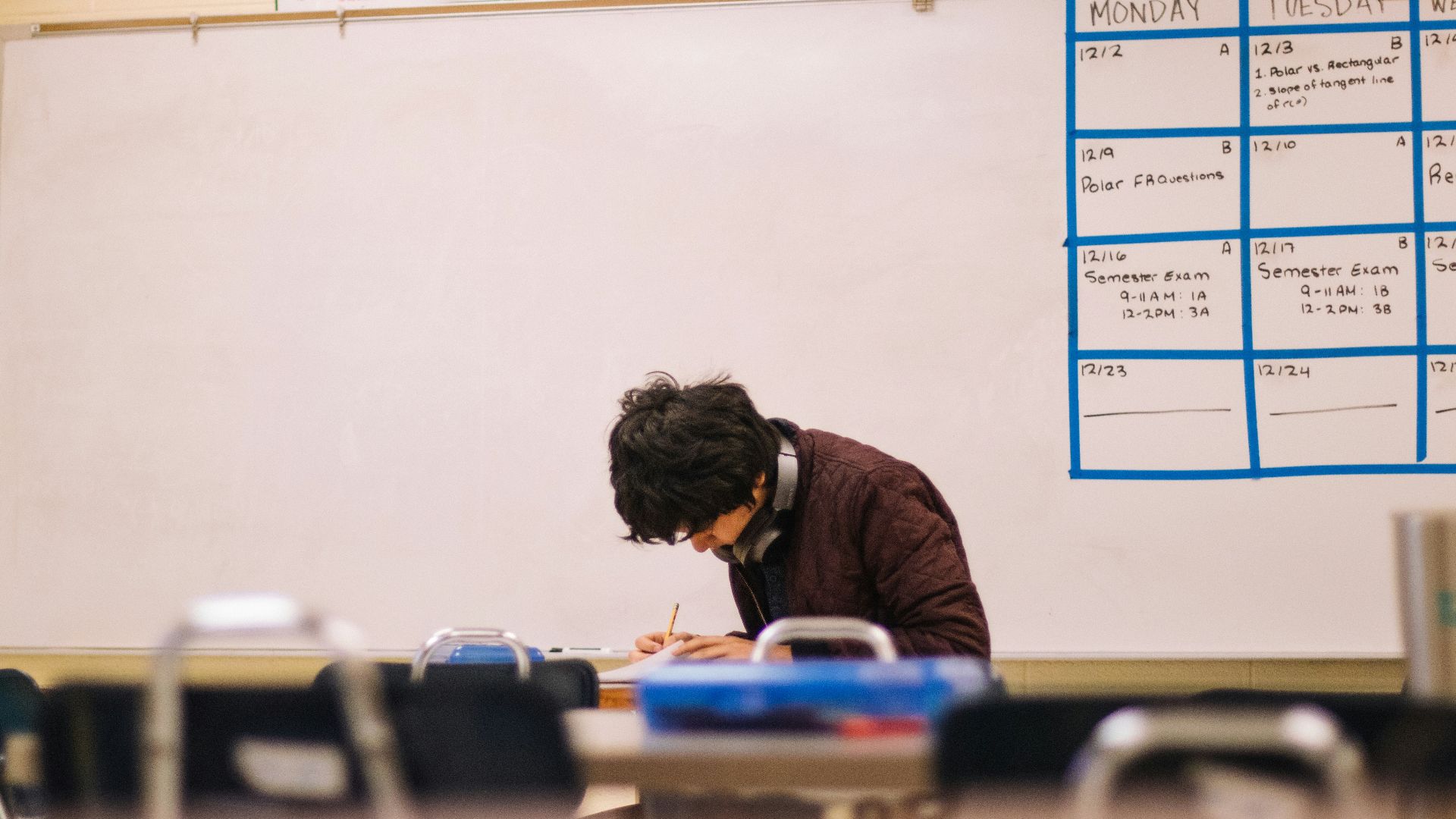 man in brown sweater sitting on chair