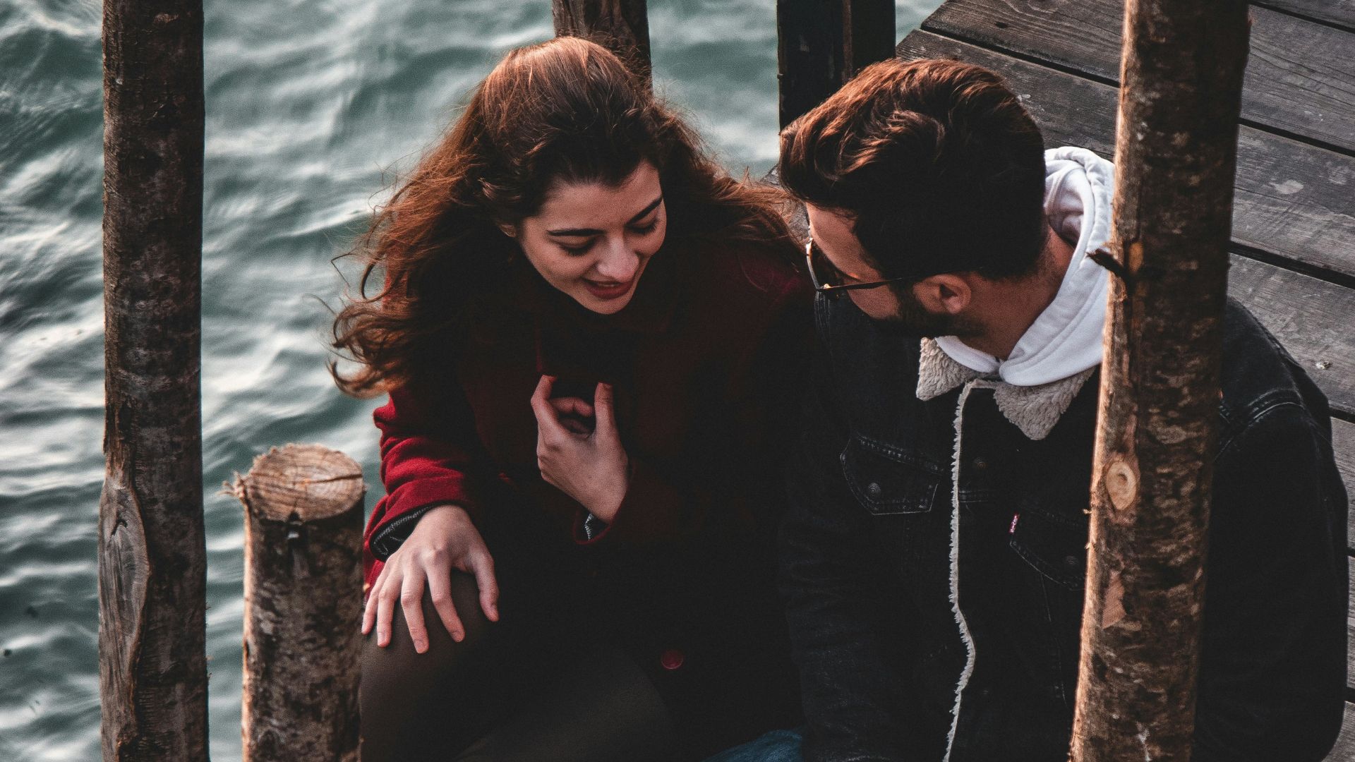 a man and a woman sitting on a dock
