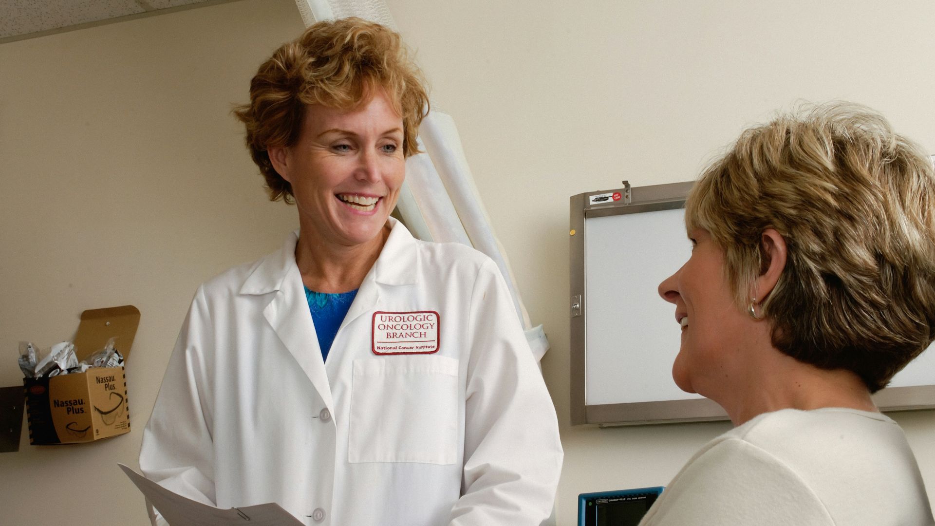 woman in white scrub suit holding gray laptop computer