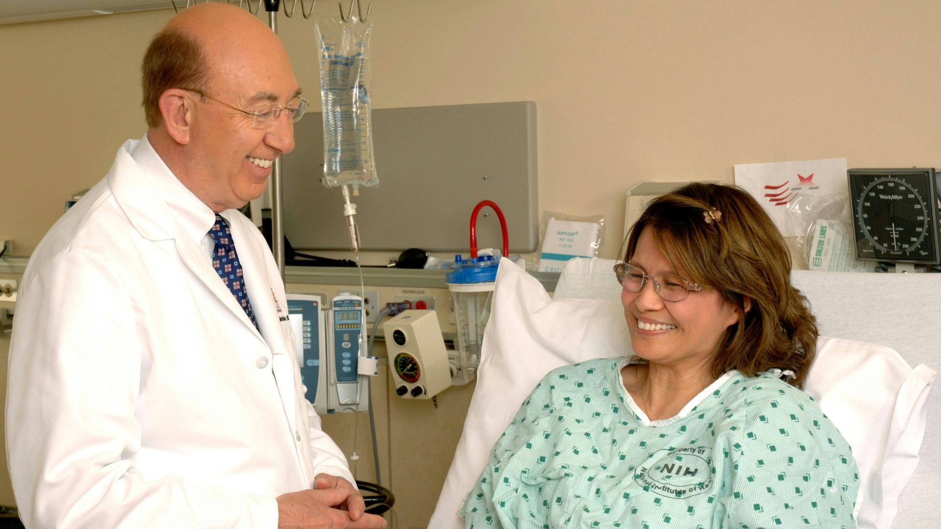 woman in teal scrub suit sitting beside man in white medical scrub suit