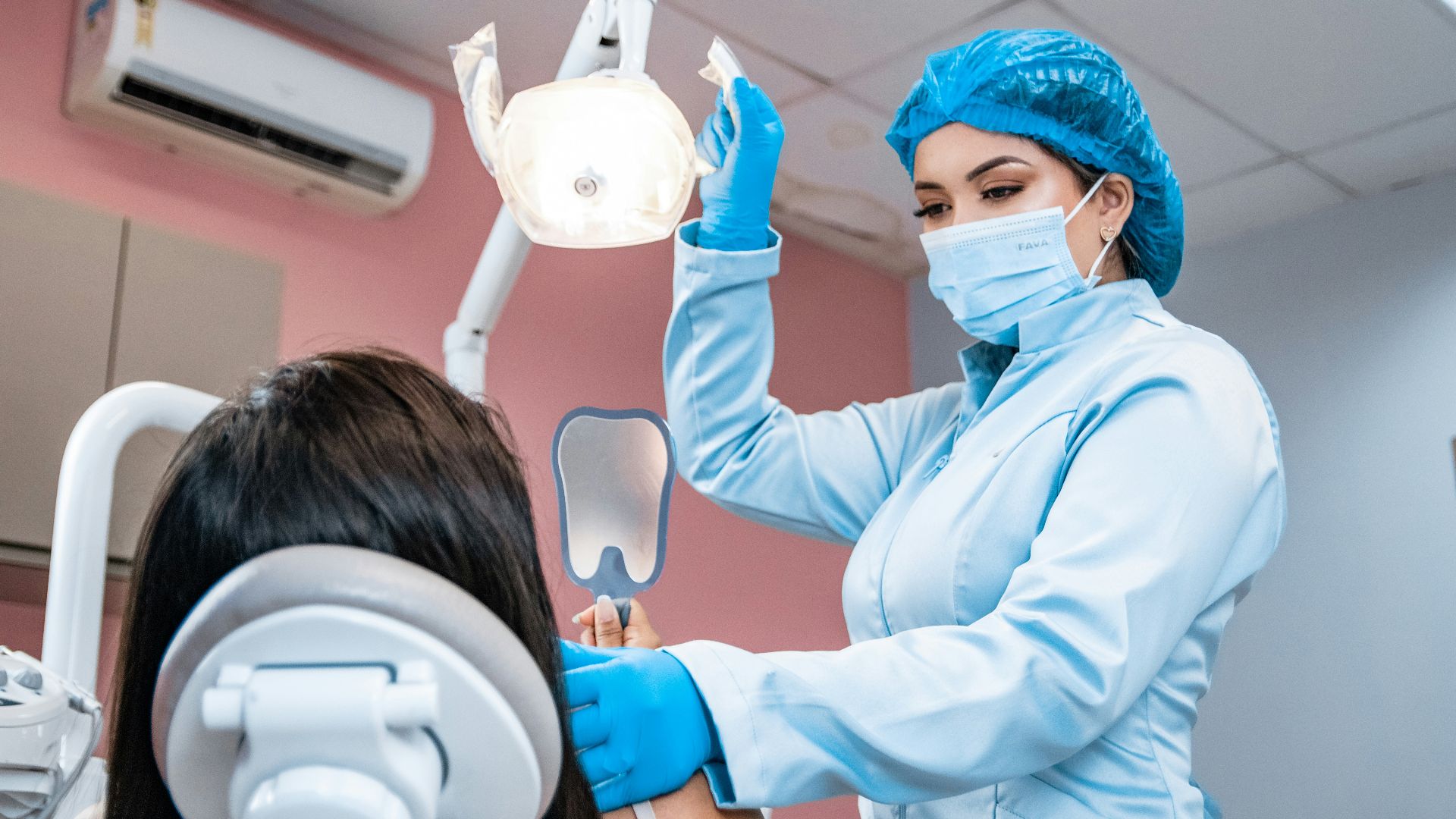 a woman getting her teeth checked by a dentist