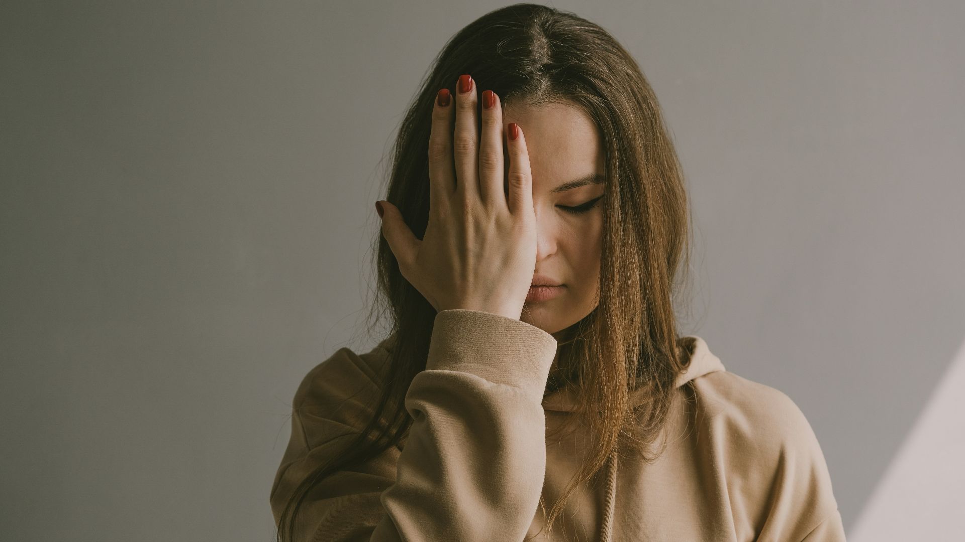 a woman covering her face with her hands