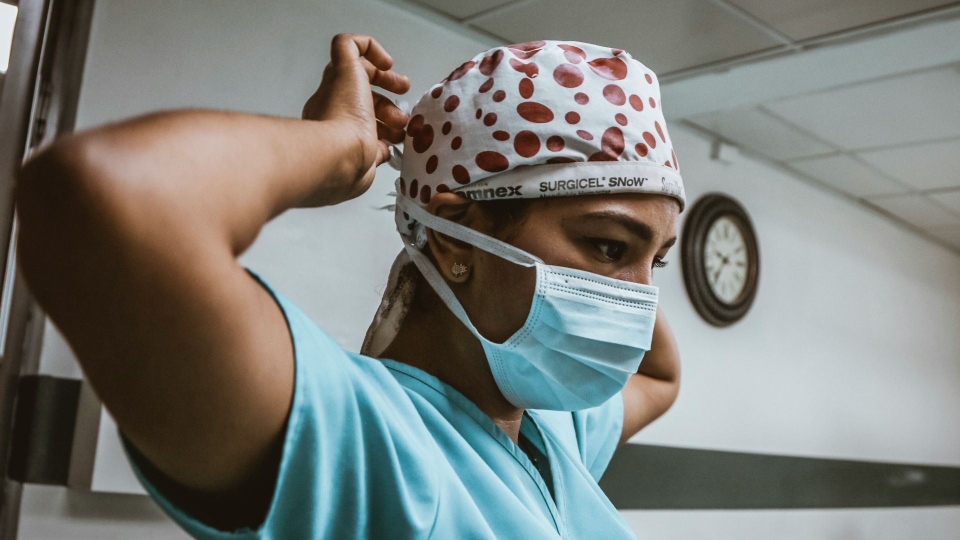 woman in teal shirt wearing white mask