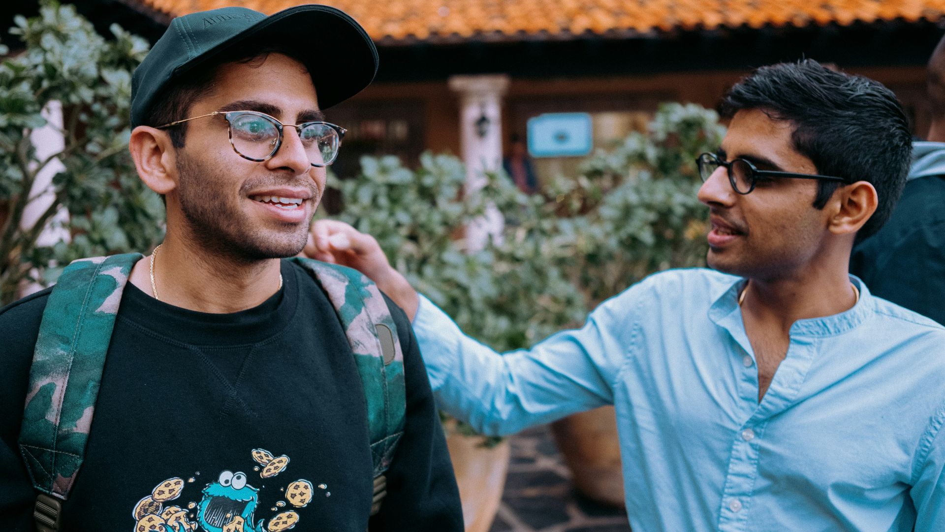 man in black crew neck shirt wearing black framed eyeglasses and black hat
