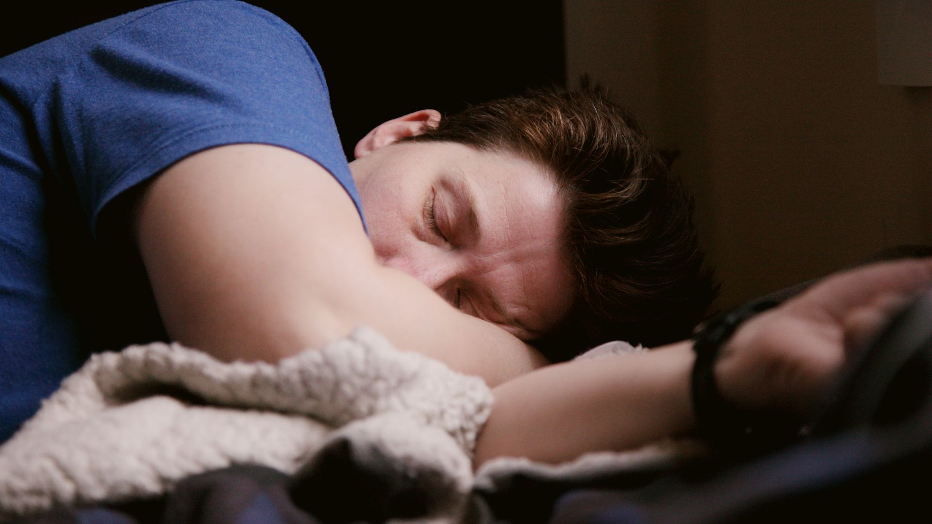 woman in blue shirt lying on bed