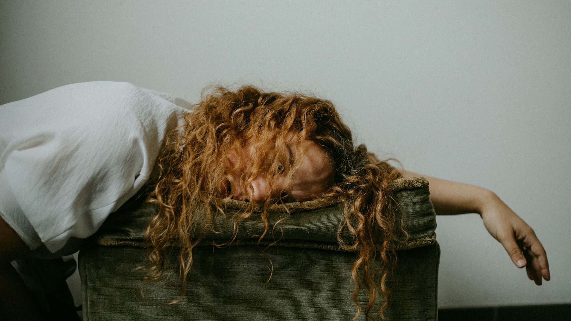 woman in white shirt lying on black textile