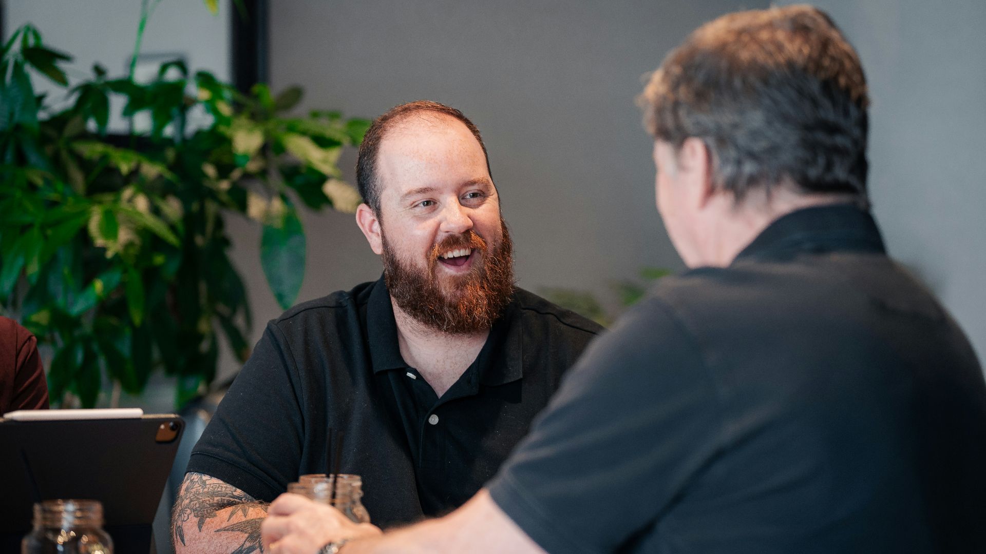 two men sitting at a table talking to each other