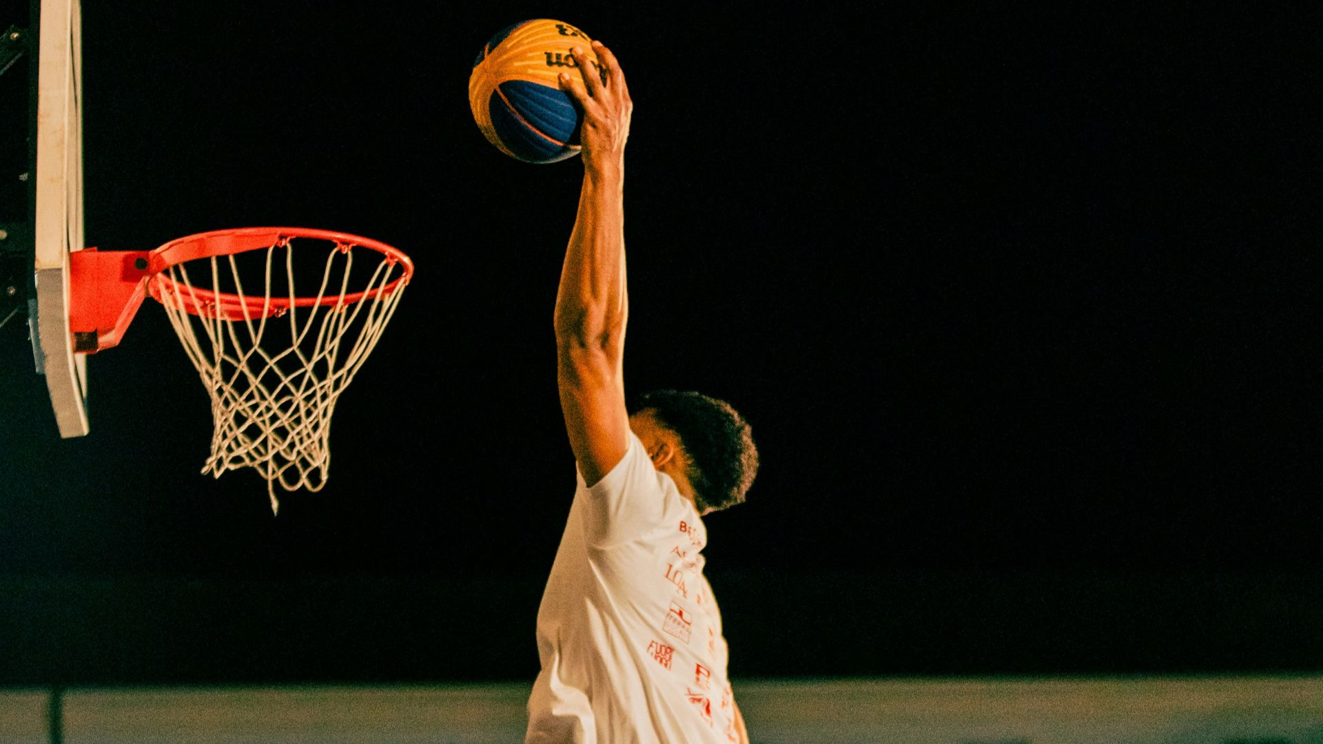 A man jumping in the air to dunk a basketball