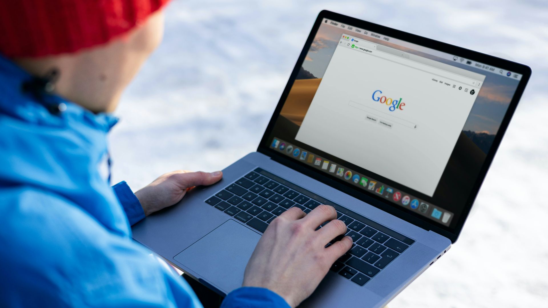 person in blue long sleeve shirt using macbook pro