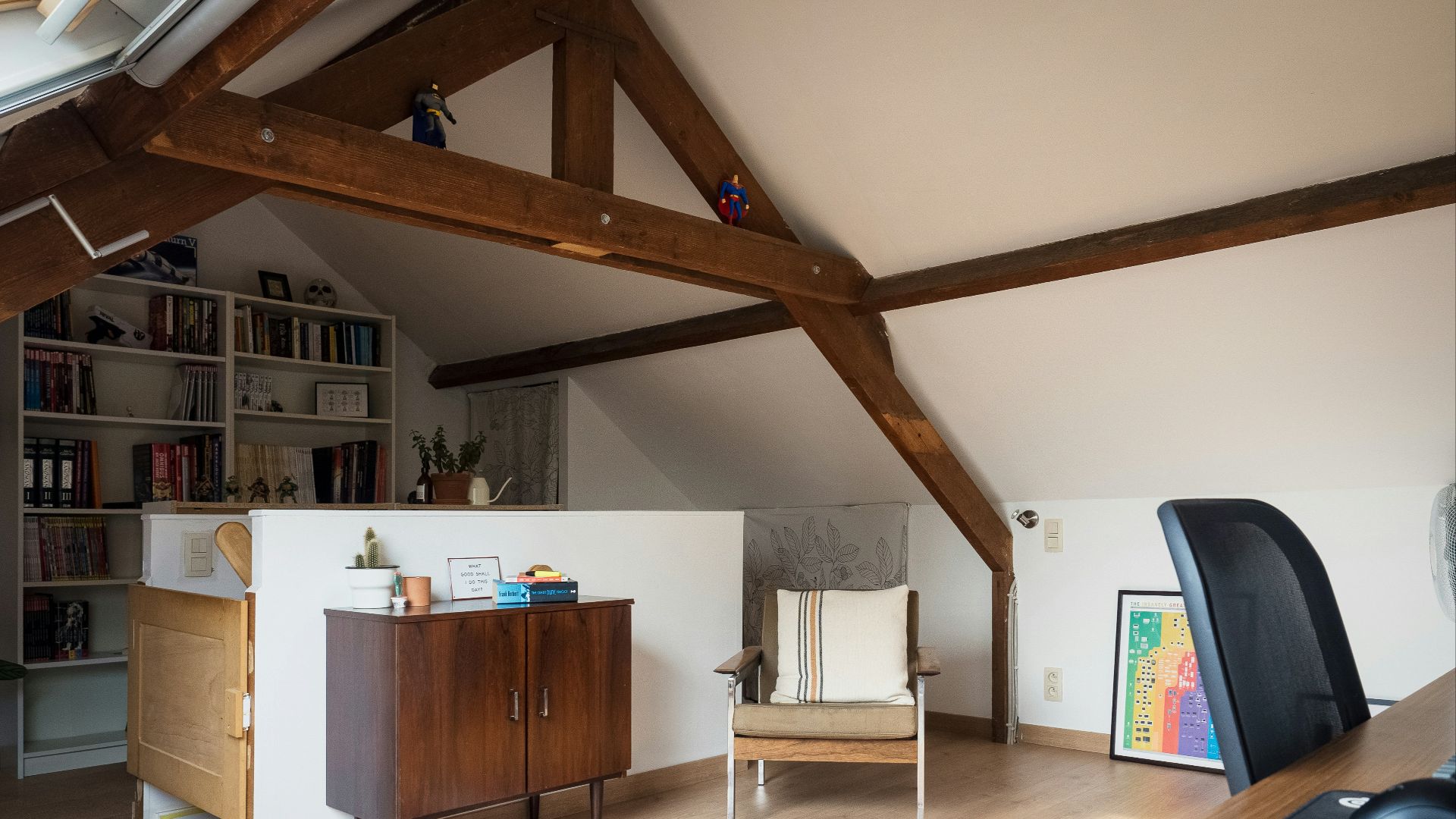 a living room with a chair and a book shelf