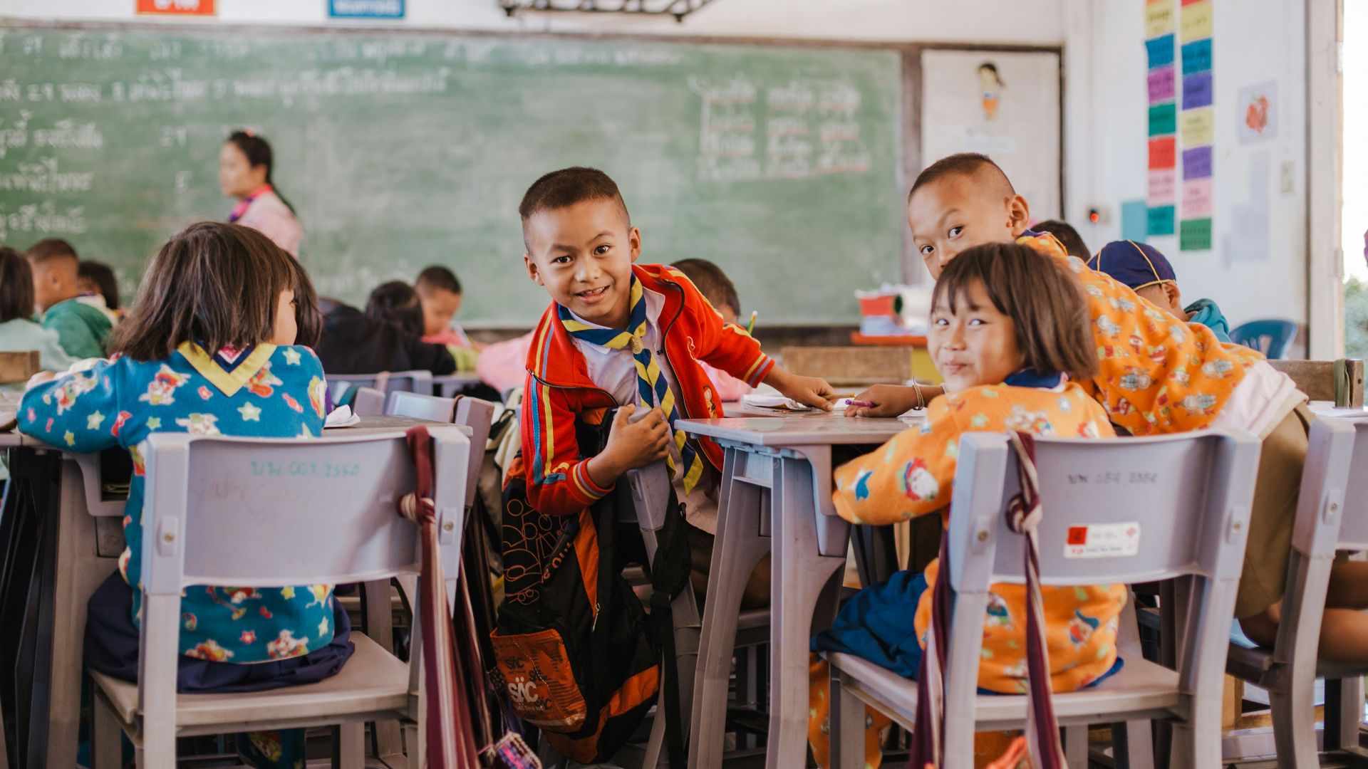 a group of children sitting at desks in a classroom
