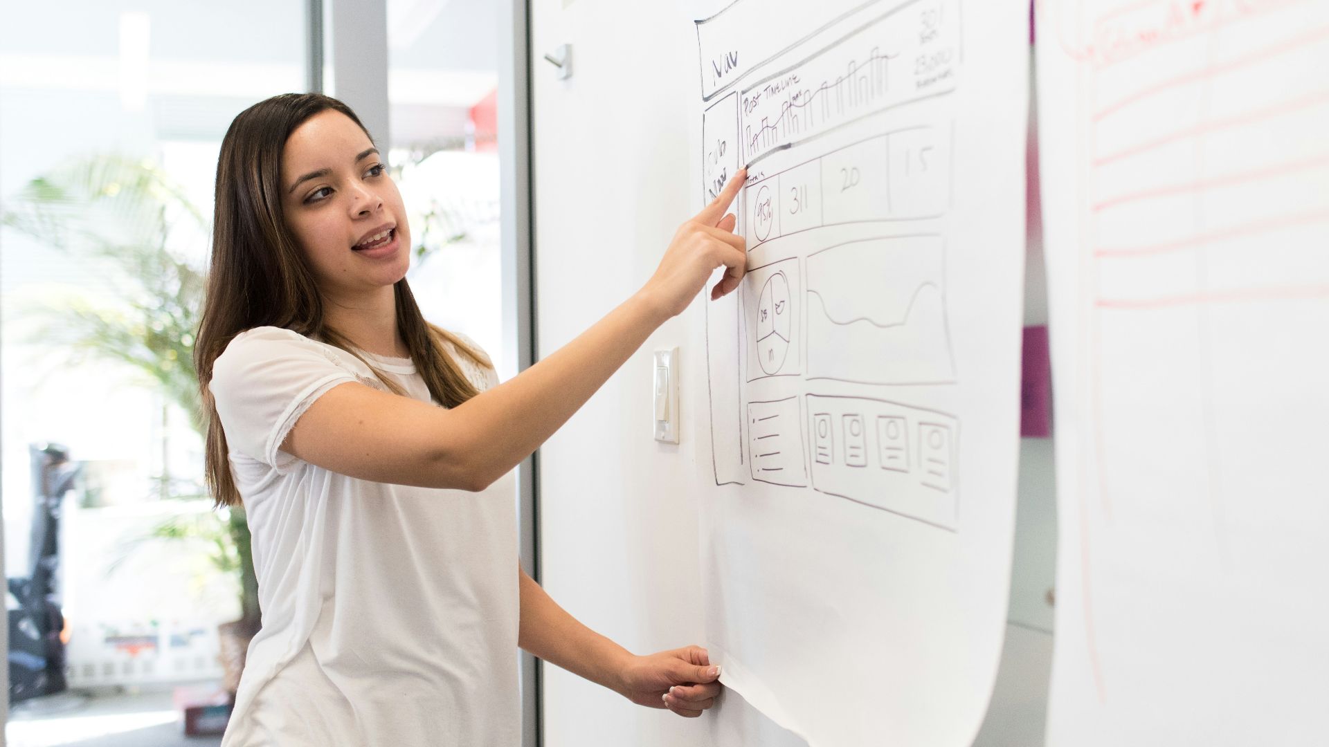 woman standing pointing paper on board