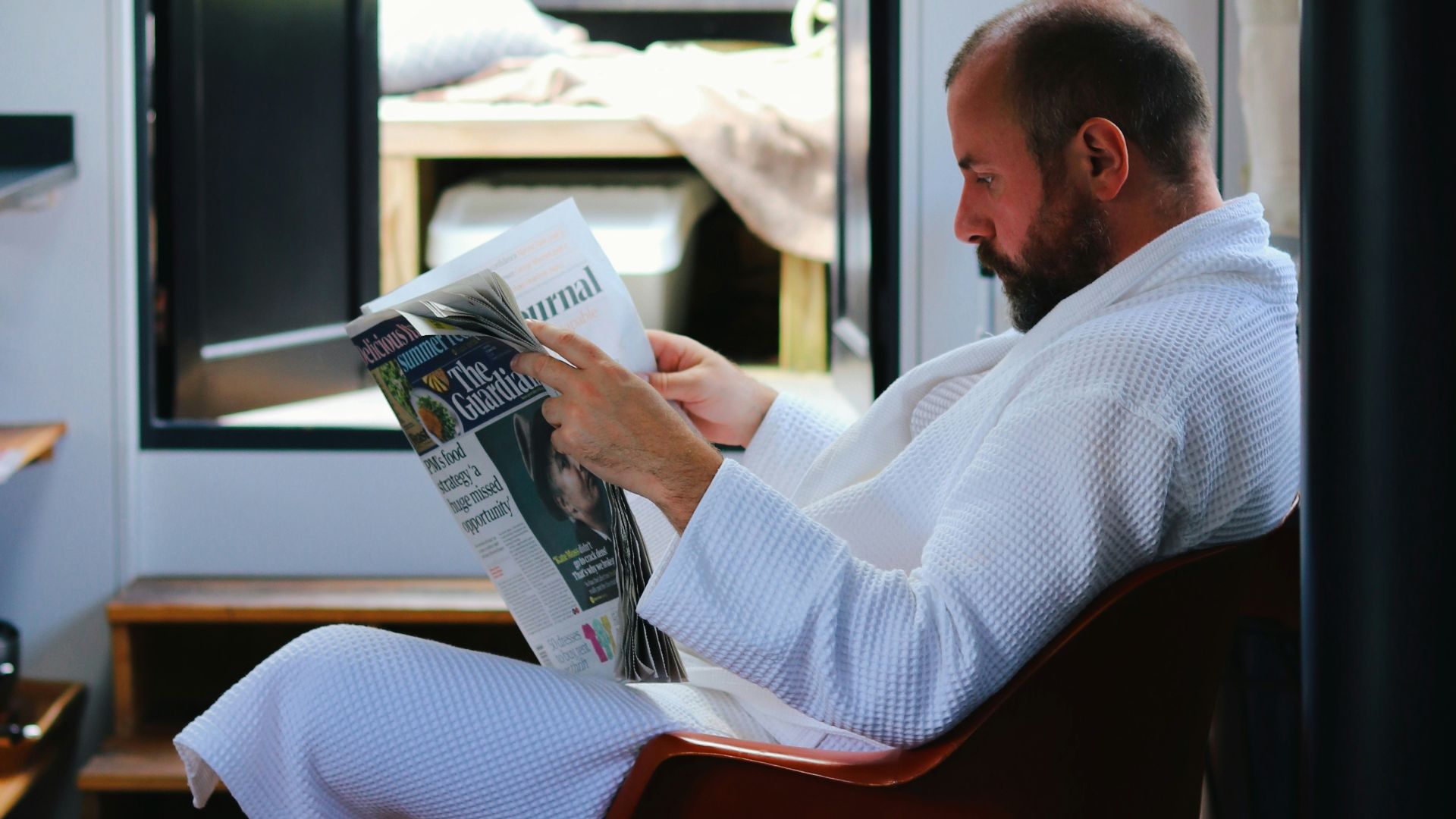 a person sitting in a chair reading a book