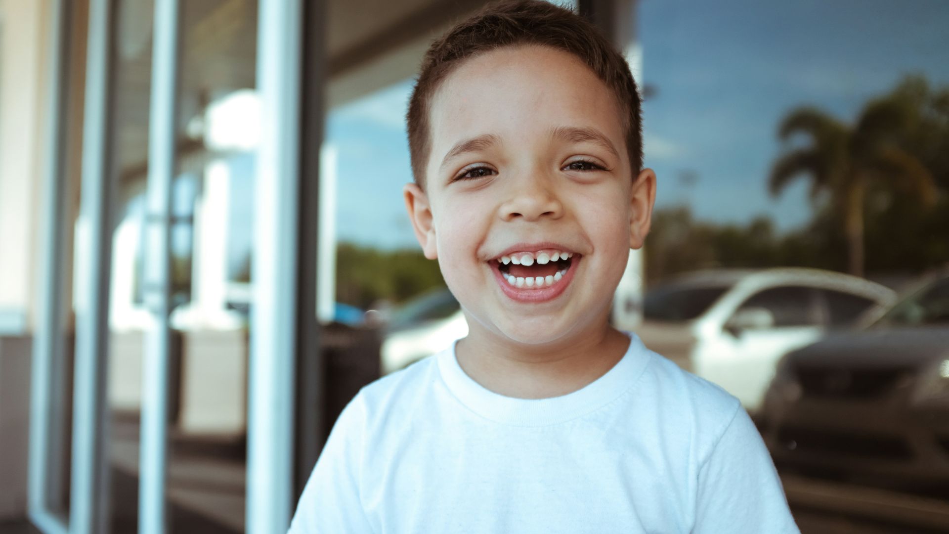 smiling boy wearing white crew-neck t-shirt during daytime