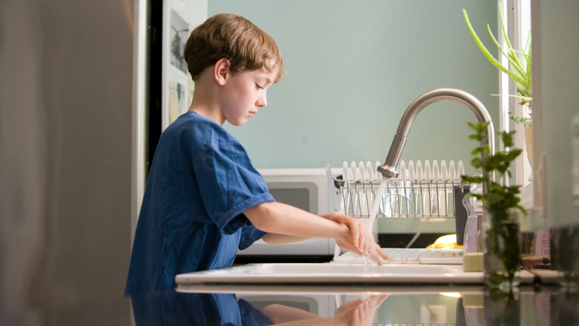 boy in blue crew neck t-shirt standing beside white wooden door