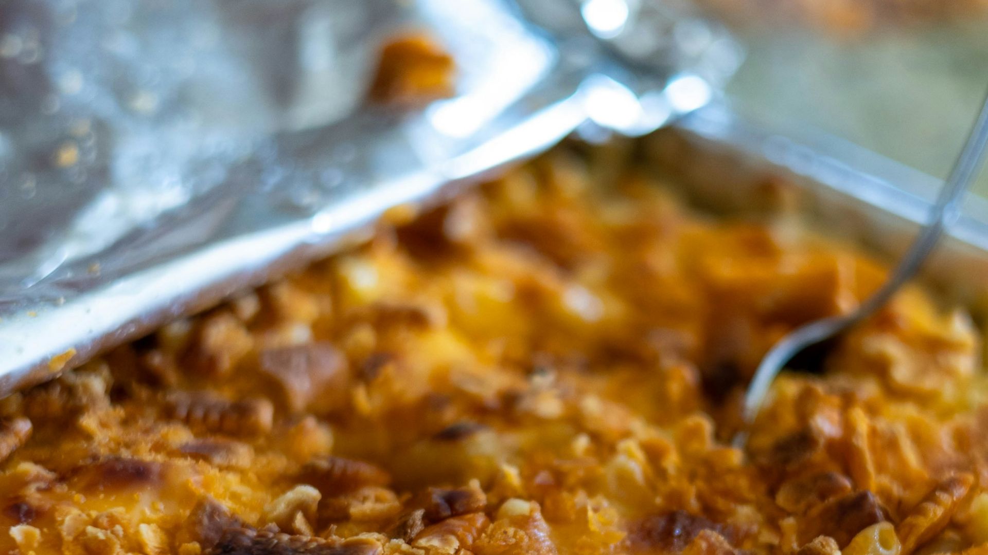 a dish of macaroni and cheese with a spoon in it