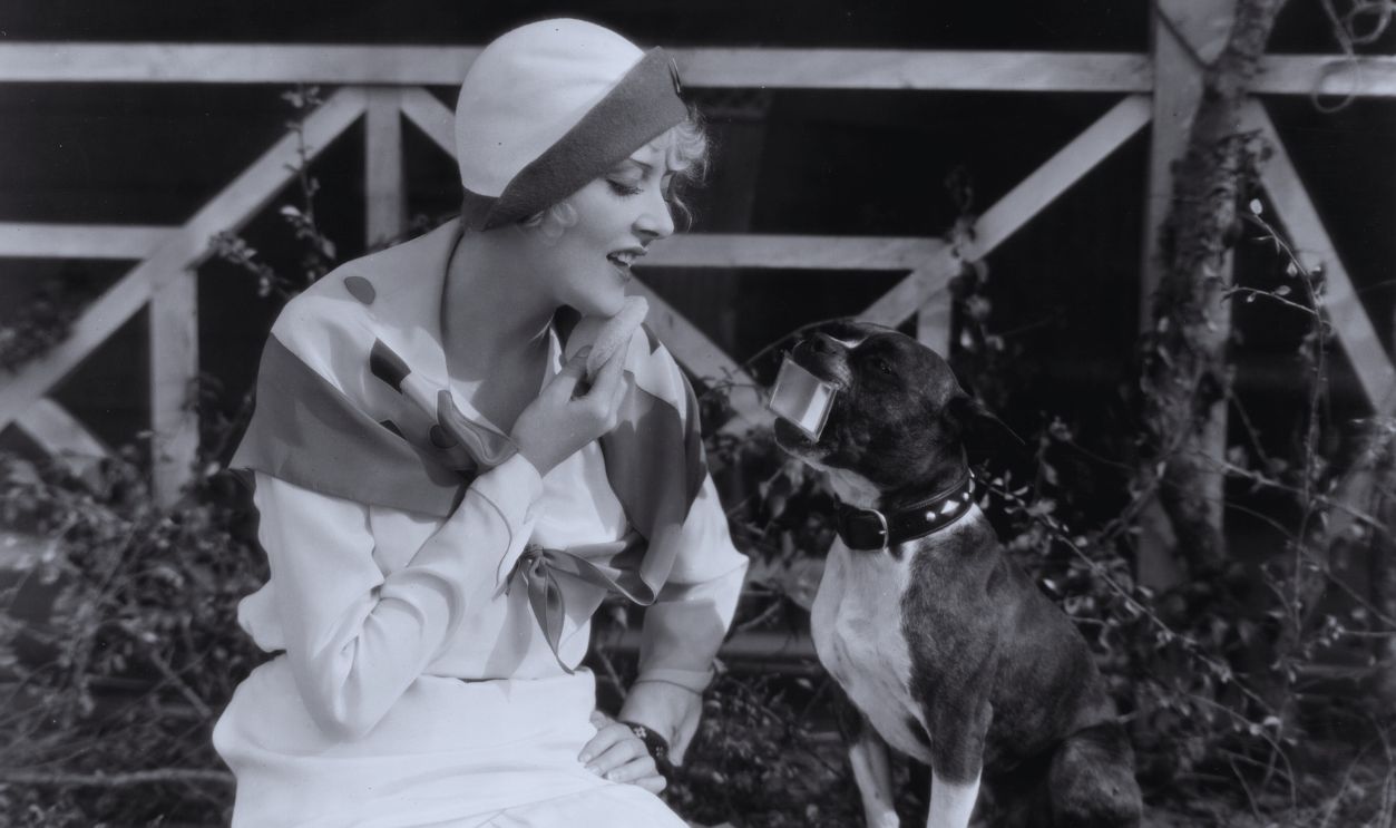 Gettyimages - 3203647, Woman's Best Friend 1929: American actor Mary Nolan seated on the ground and powdering her chin while looking into a compact mirror held for her in the mouth of a dog. 
