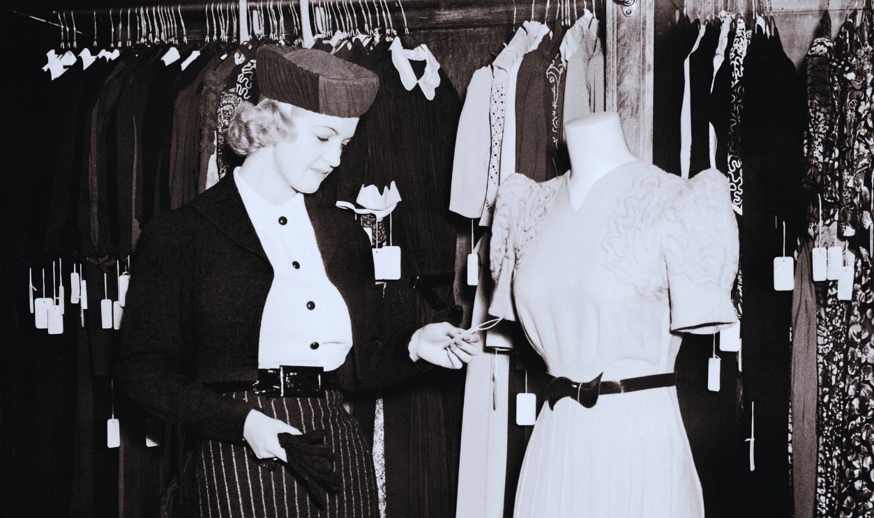 Gettyimages - 1322886992, How Much? 1930s Blonde Woman Shopper Checking The Price Tag On A Dress In A Department Store. 