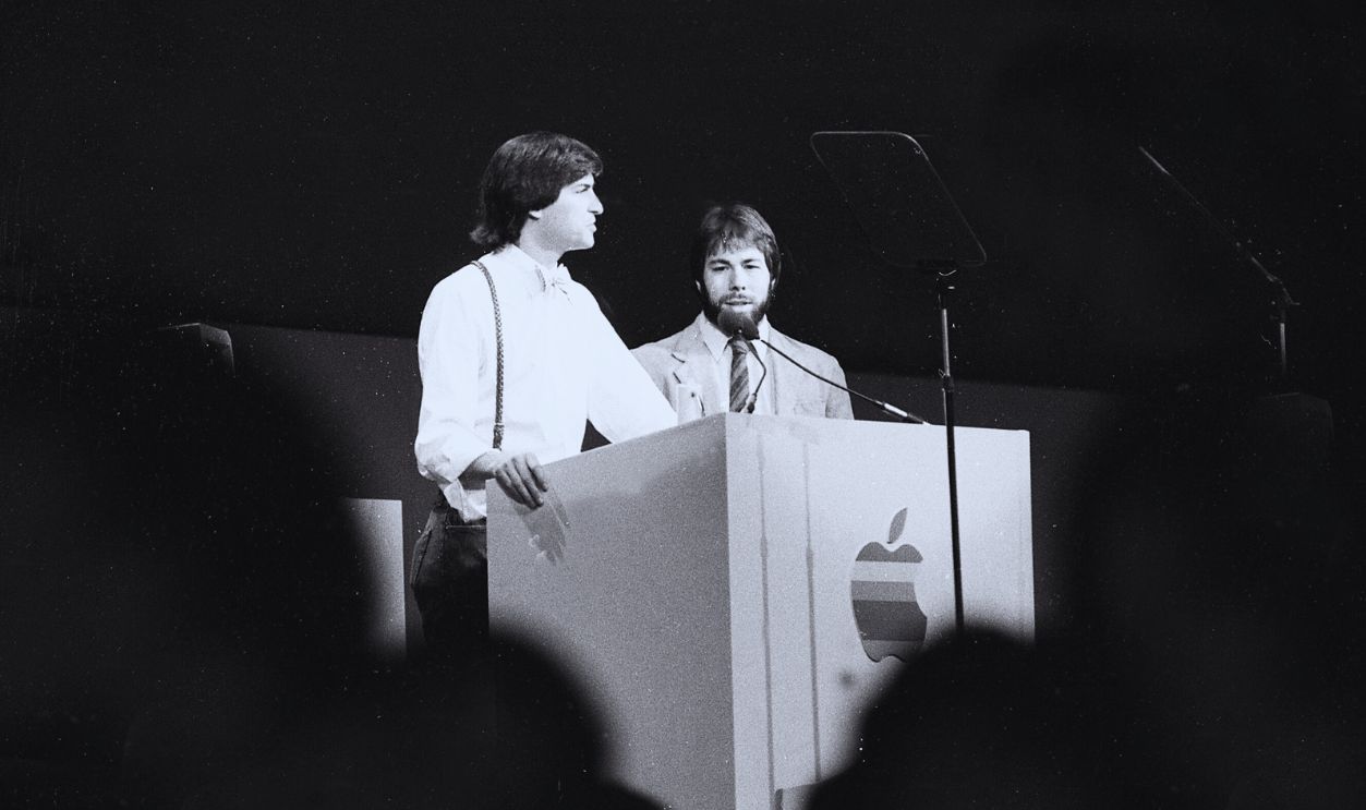 Gettyimages - 1206184611, April 23, 1984: Apple executives Steve Jobs and Steve Wozniak at a podium during the 