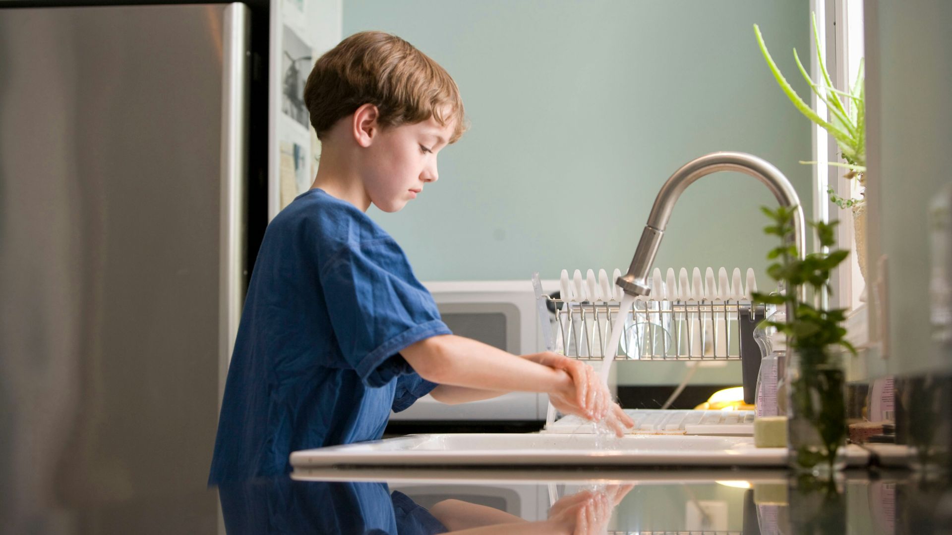 boy in blue crew neck t-shirt standing beside white wooden door