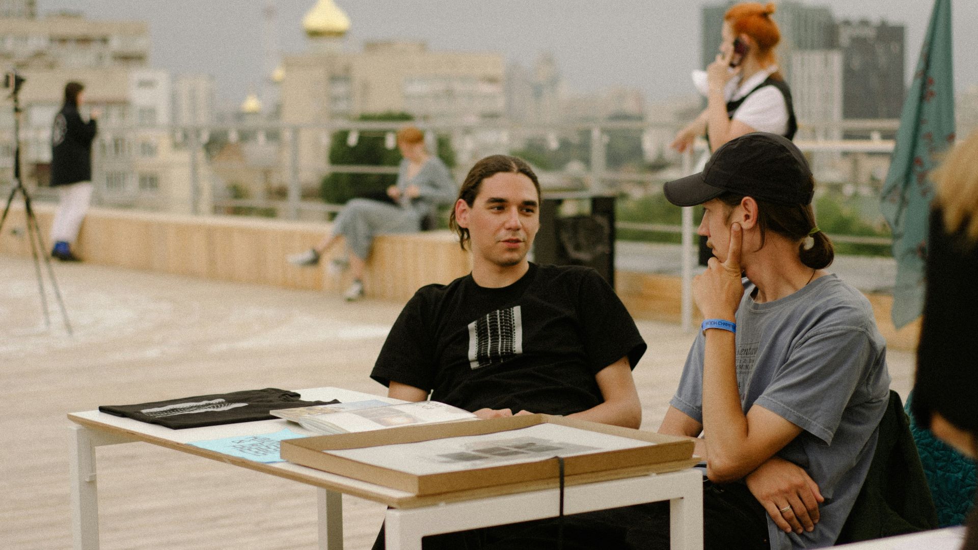 a man sitting at a table talking on a cell phone