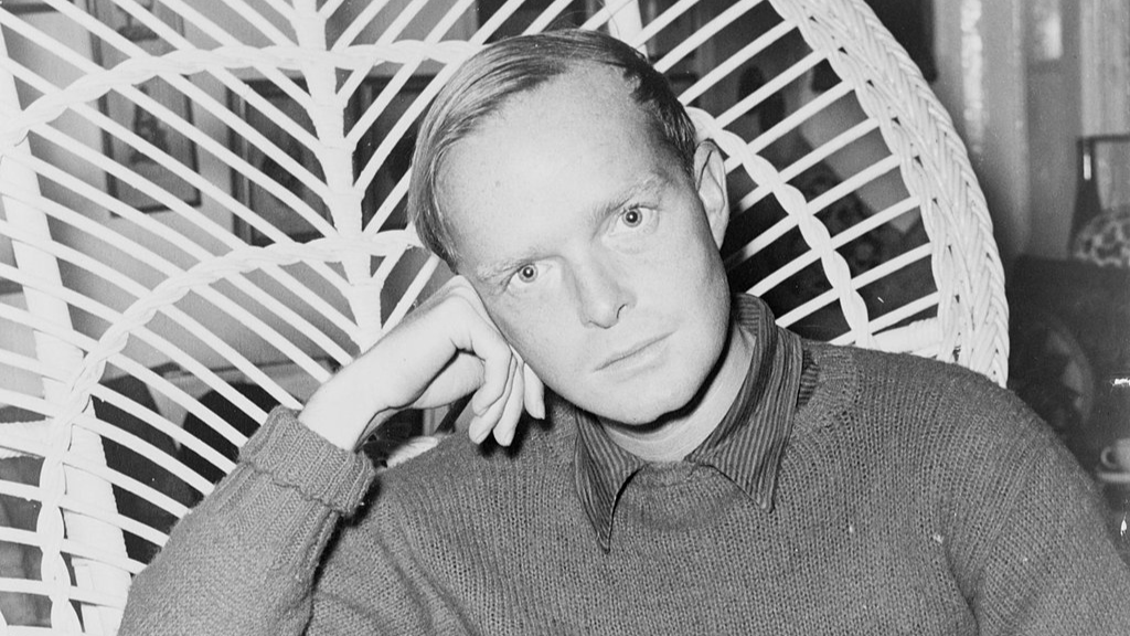 Truman Capote, half-length portrait, facing front, seated in a chair, resting head on his hand