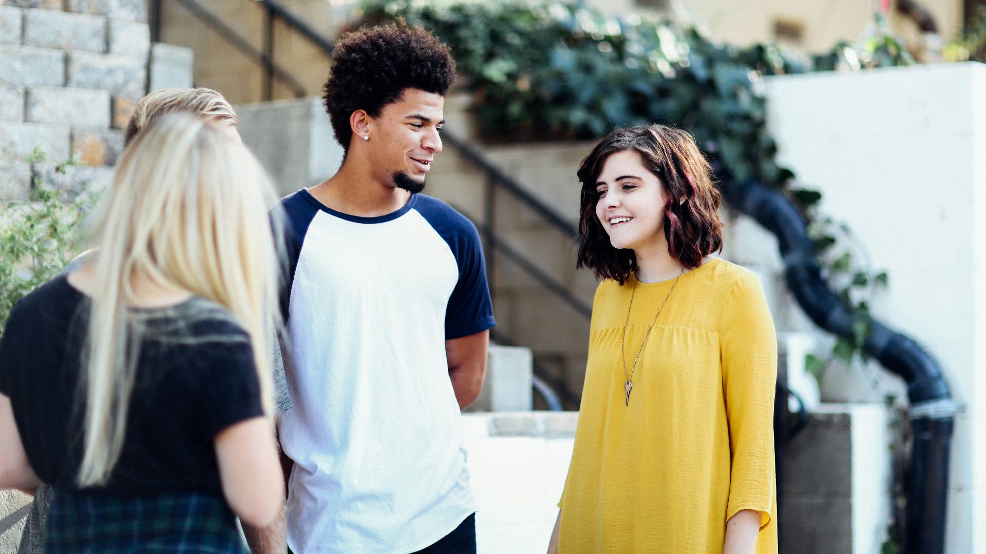 women and man talking outside the building